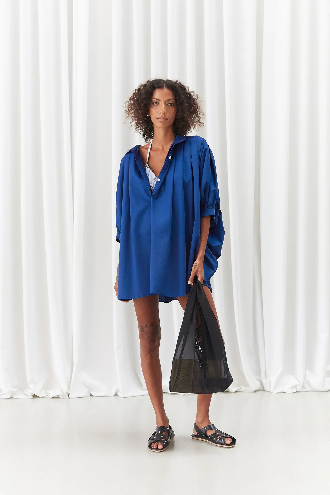 J.Kim petal tote in black, full-length front view of the sheer tote carried by a model in a Intellectual Leisure blue top