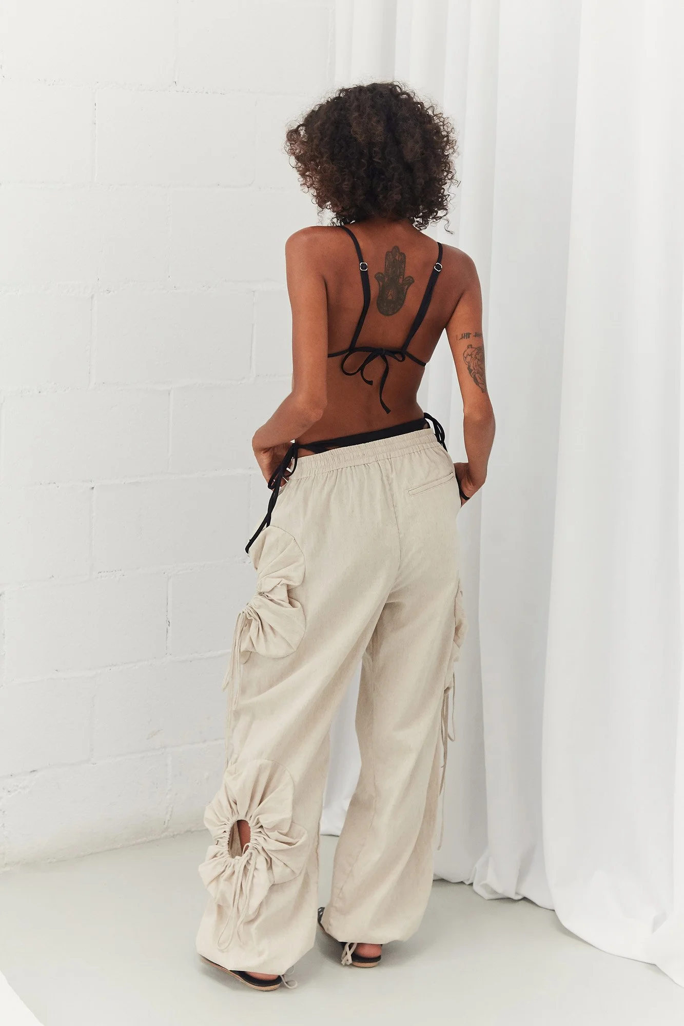 J.Kim linen flower pant in cream, back view showing the relaxed wide-leg cut and gathered floral cut-out detail at the legs