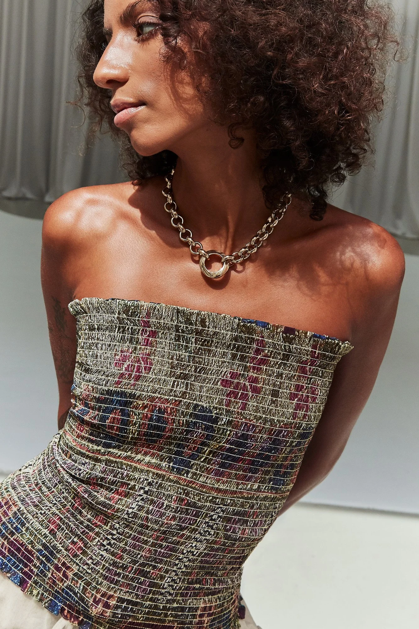 Florence Moorhead Tori Collier necklace in pale gold, front view of the chain-link necklace with ring pendant, styled with a strapless top