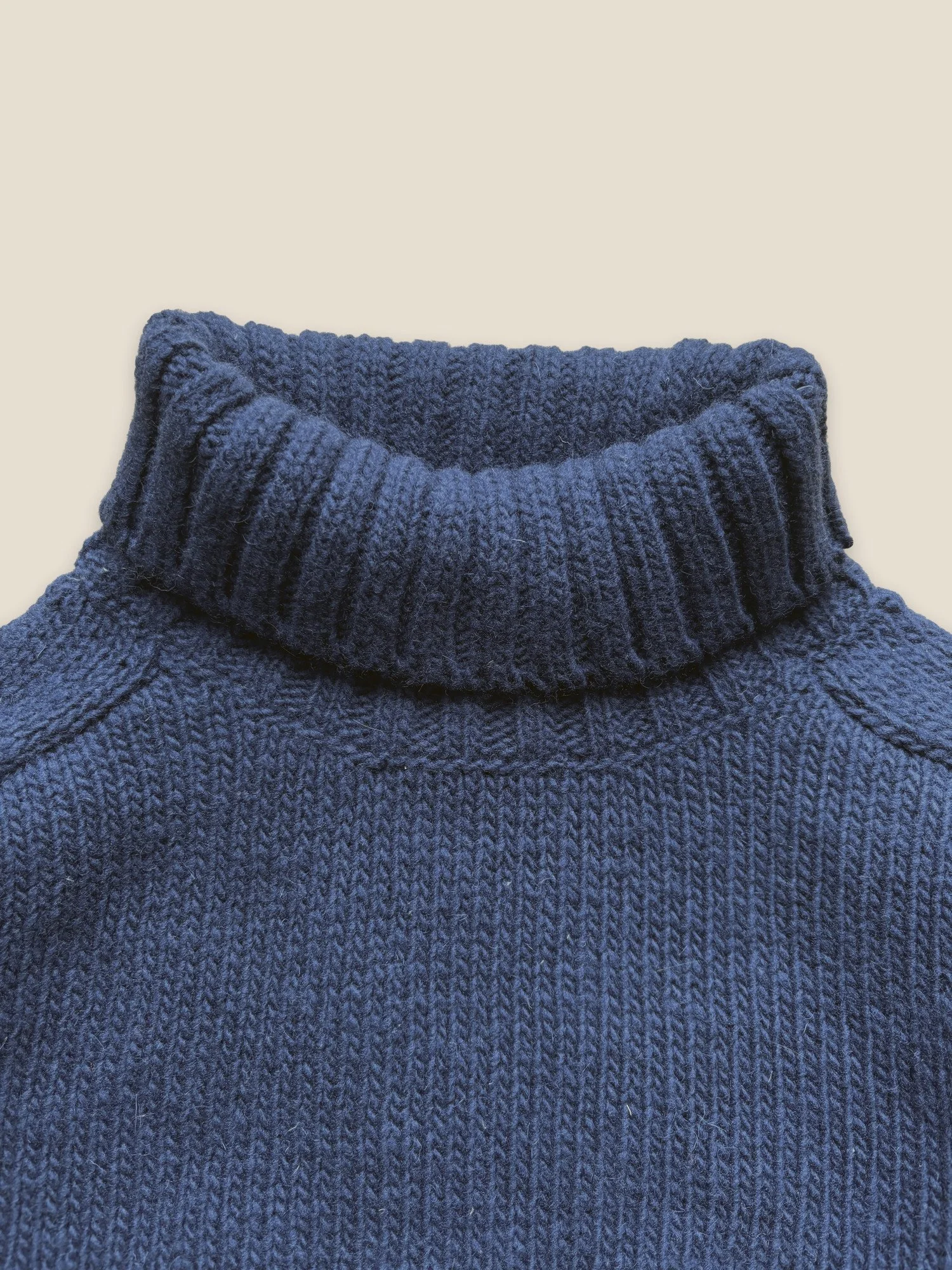 Close-up of the Floca Ringo Sweater in ink blue with the ribbed turtleneck folded down