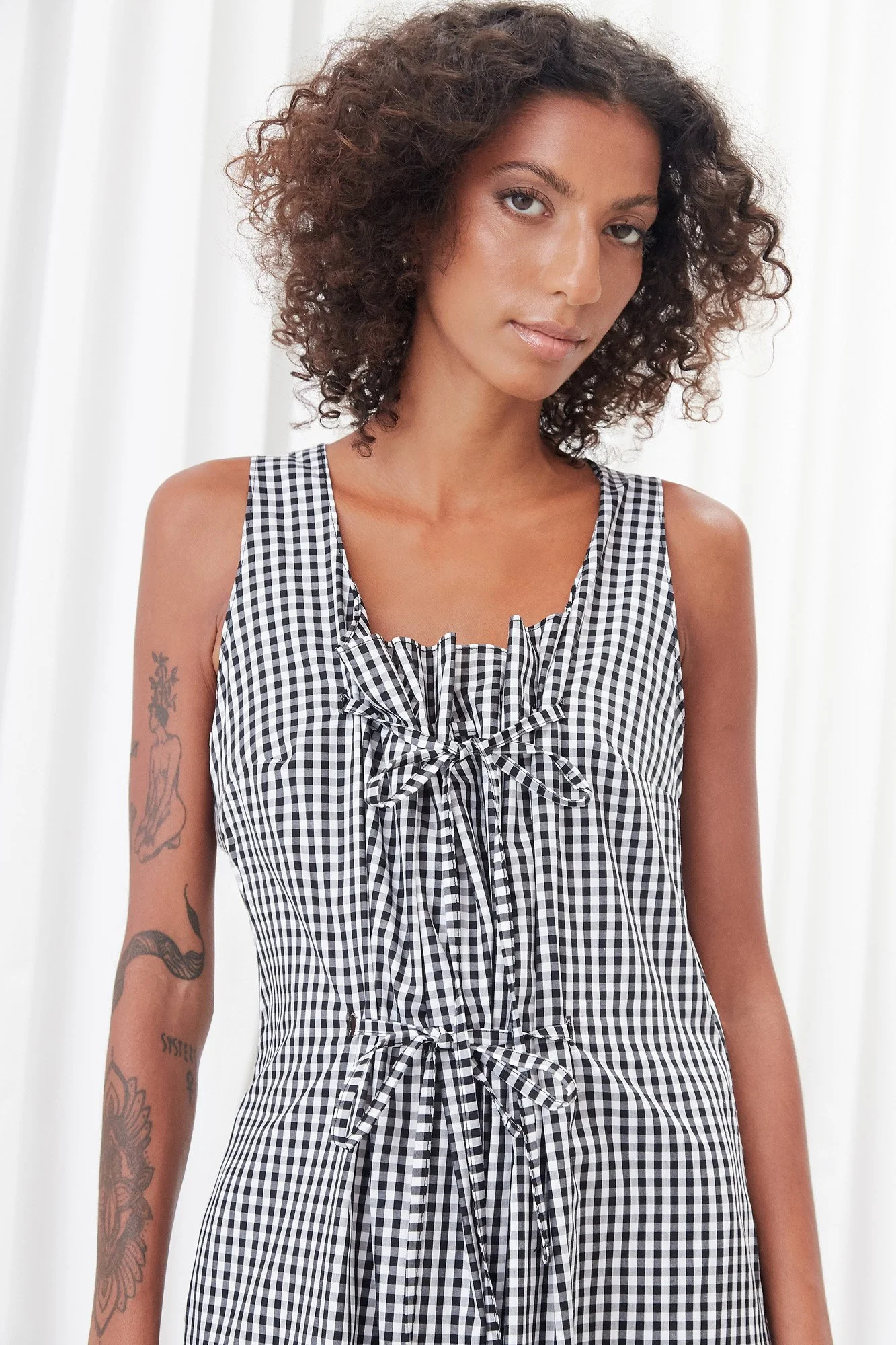 Intellectual Leisure Eirini dress in black and white check, close-up of the scoop neckline and front self tie detail