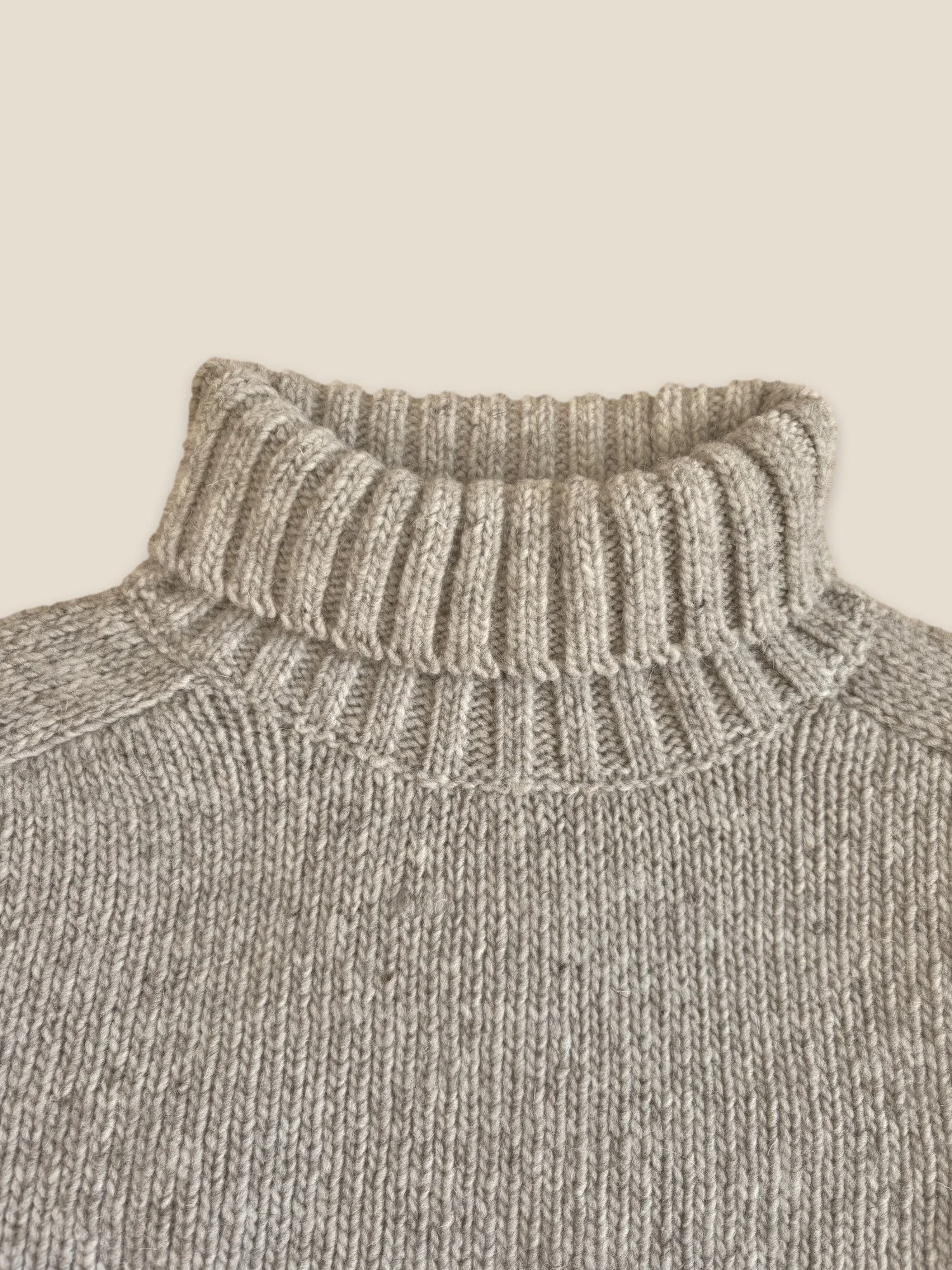 Close-up of the Fog Grey Ringo Oversize Sweater by Floca with the ribbed turtleneck folded down.