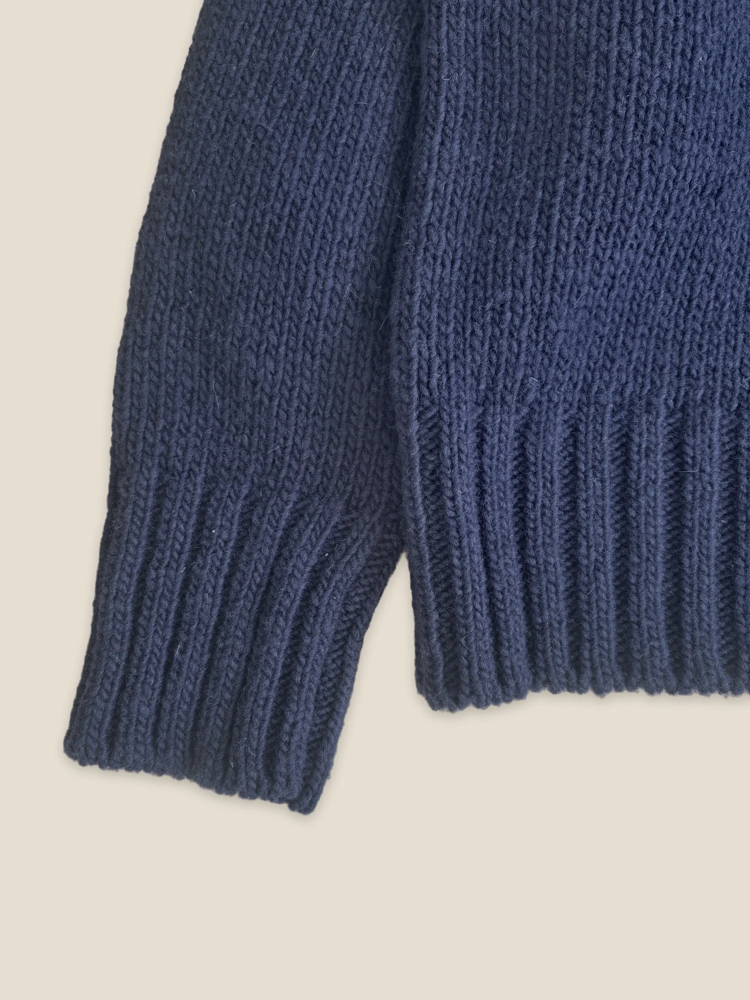 Close-up of the ribbed cuff and hem on the Ink Blue Ringo Oversize Sweater by Floca in Spanish wool.