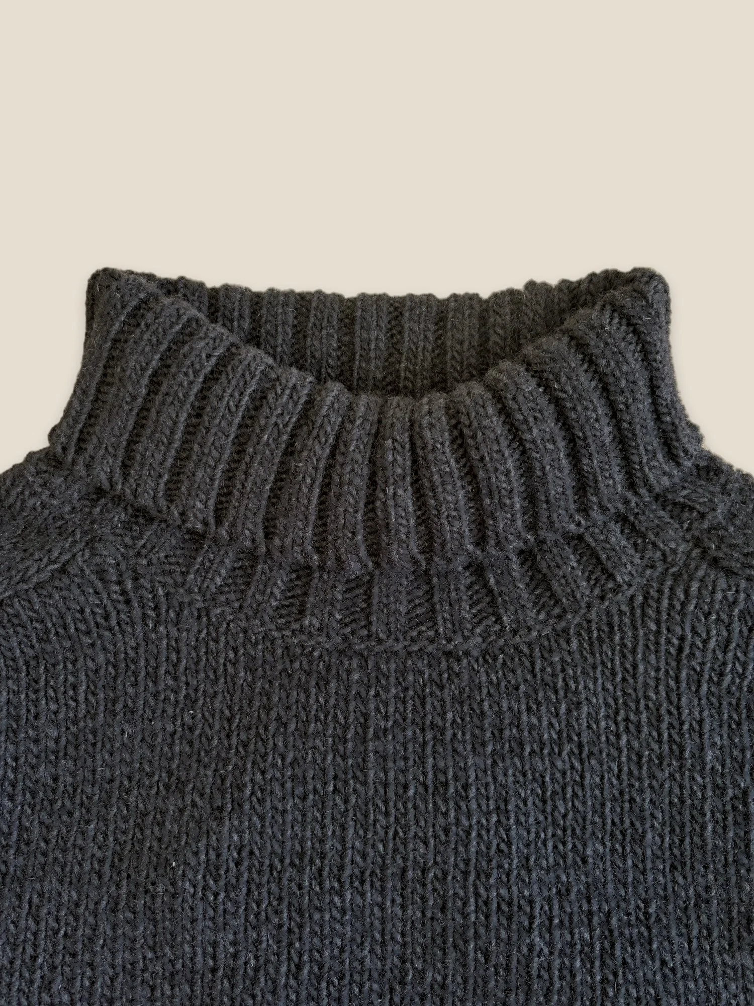 Close-up of the Black Ringo Oversize Sweater by Floca with the ribbed turtleneck folded down.