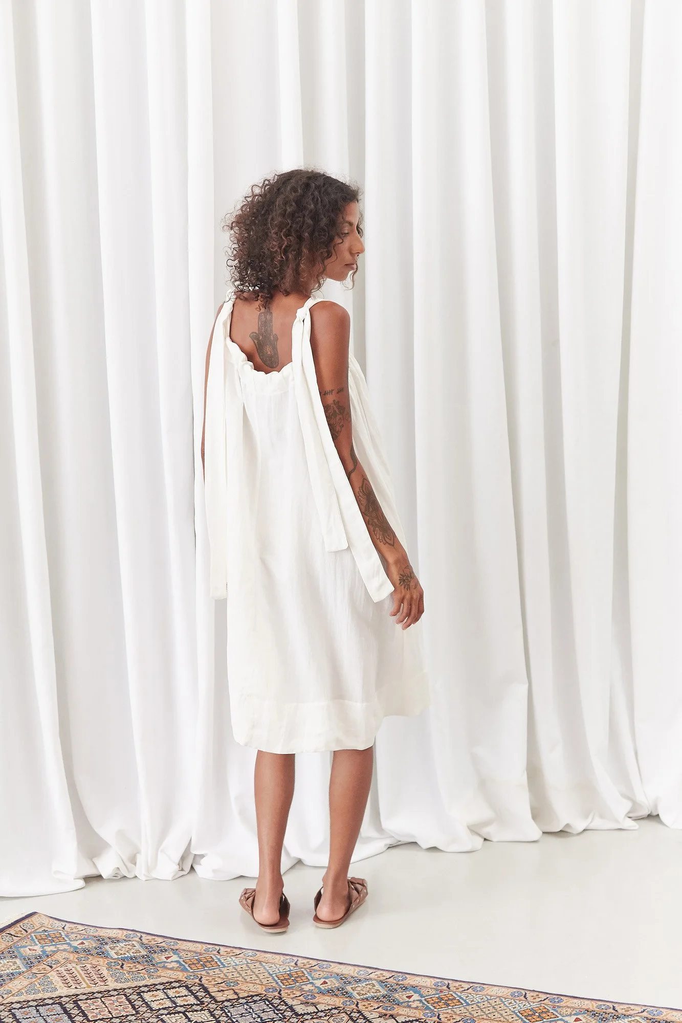Intellectual Leisure Bow Dress in white, full-length back view showing the low scooped back and relaxed midi silhouette