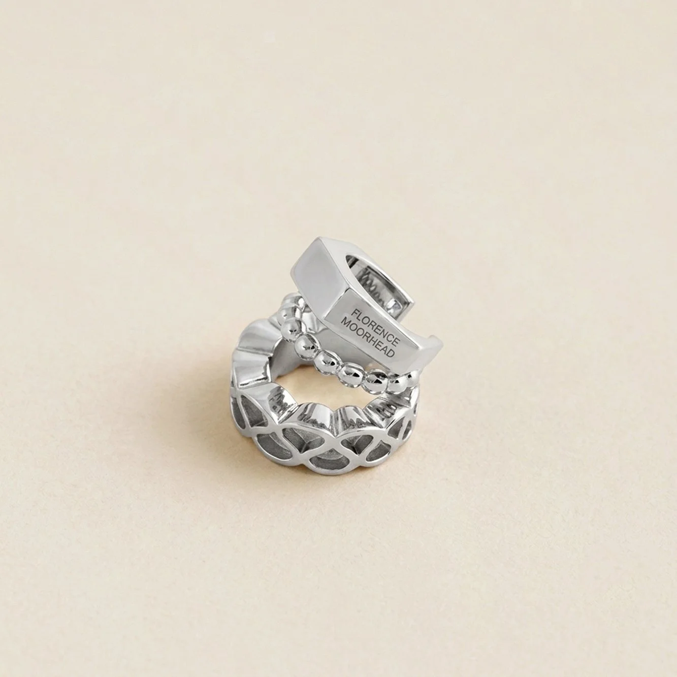 Angled view of the Florence Moorhead x Solène Lescouët Collerette Ear Cuff from the opposite side, with Florence Moorhead engraved on the faceted band.