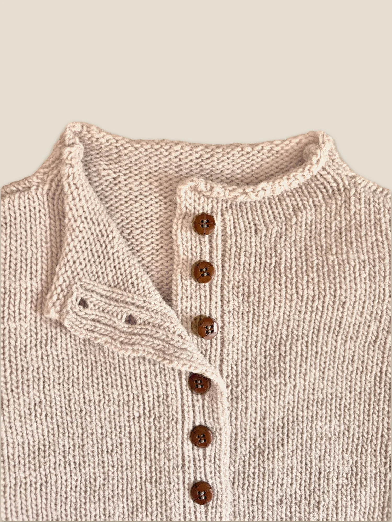 Close-up of the collar and button front on the Pale Rose Pomba Cardigan by Floca in Spanish wool.