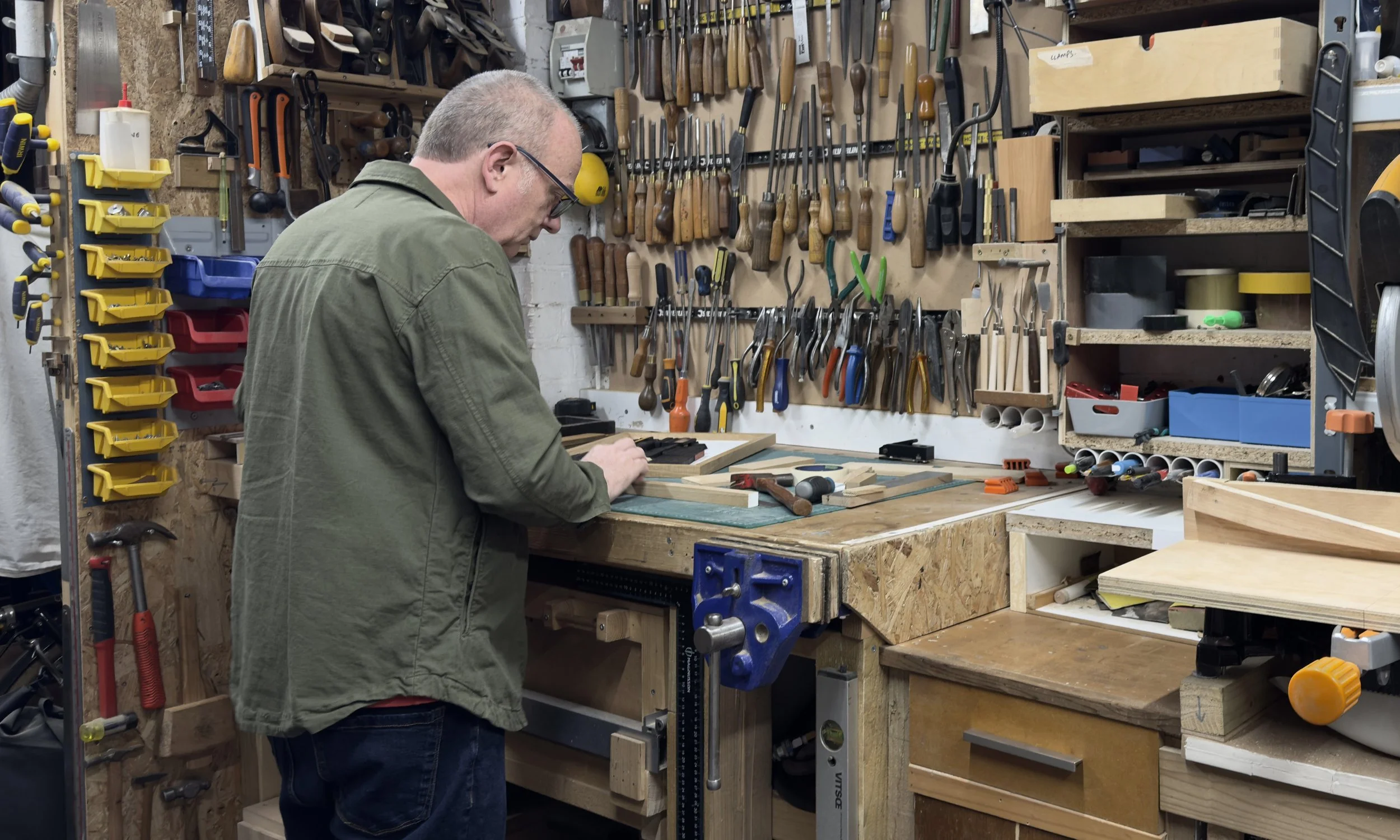 An artist working with hand tools in his studio.
