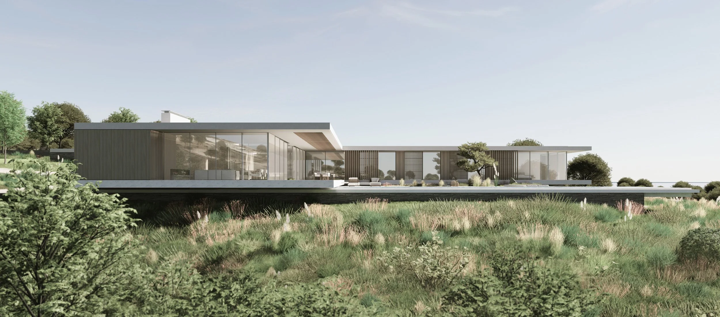 Modern, low-rise house with large glass windows, surrounded by greenery and trees, under a clear sky.