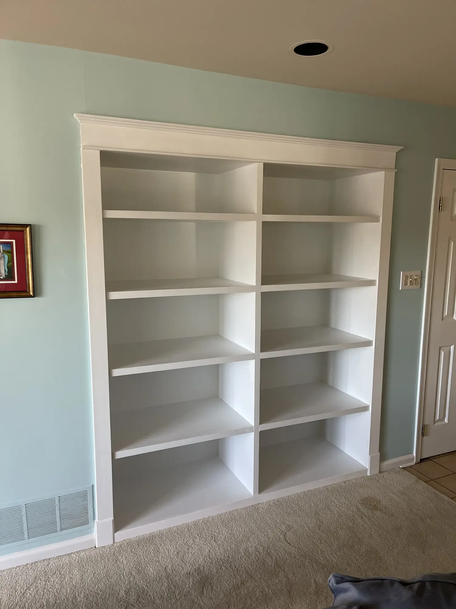Custom white built-in bookcase fitted into a Bucks County living room wall.
