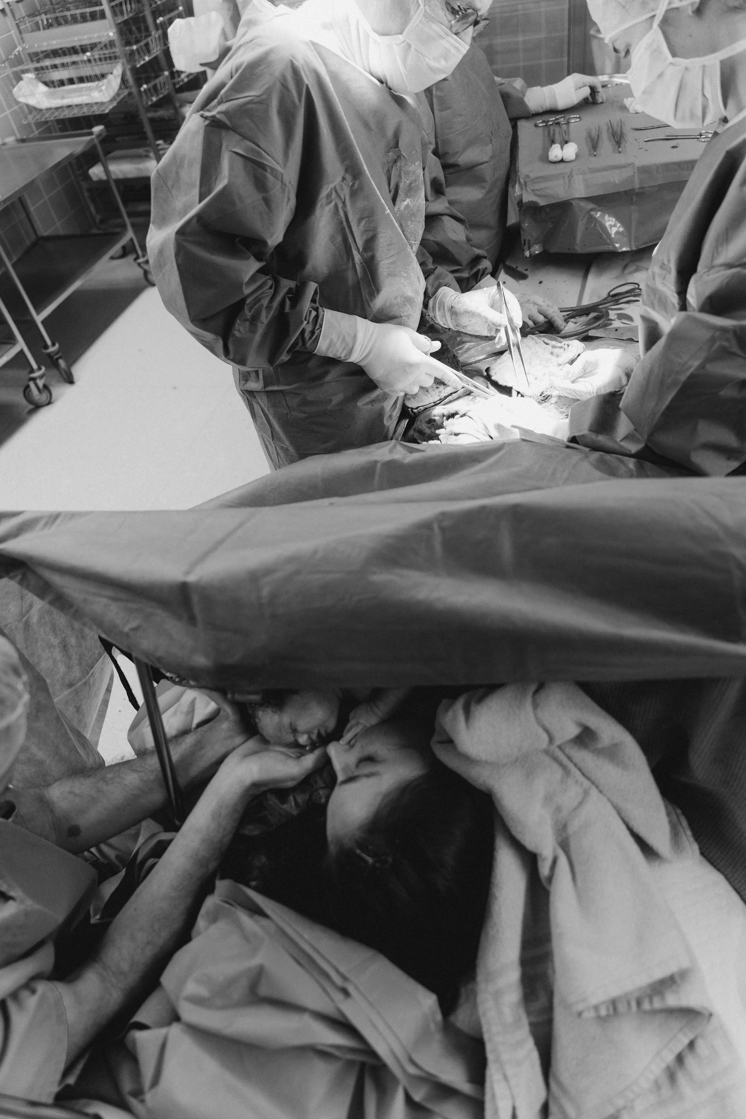 Auf dem Foto ist eine opishalle mit Chirurgen bei einer Operation zu sehen. Ein Patient liegt auf dem Operationstisch, während medizinisches Personal an ihm arbeitet.