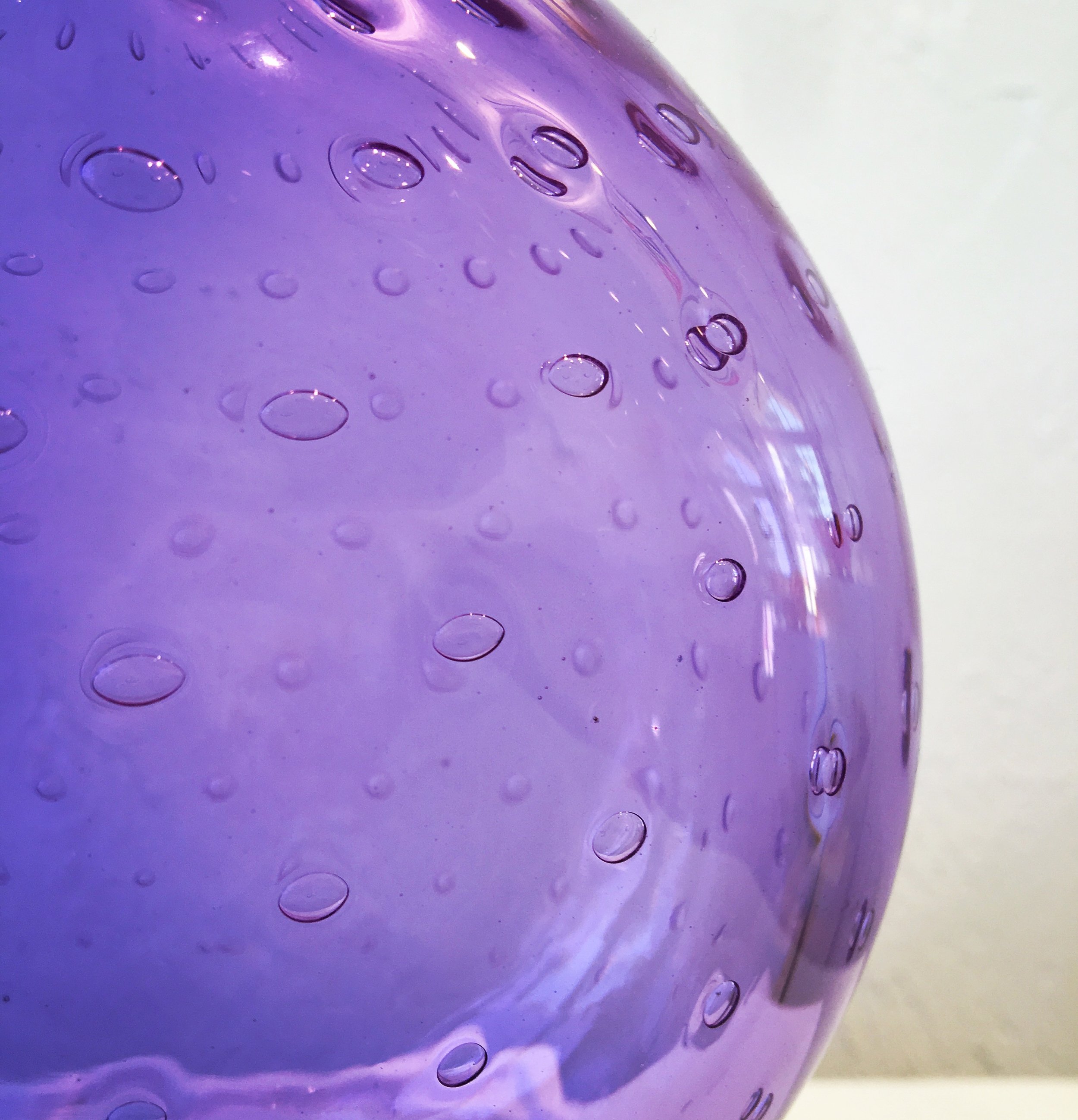 Closeup of purple glass vase with bubbles