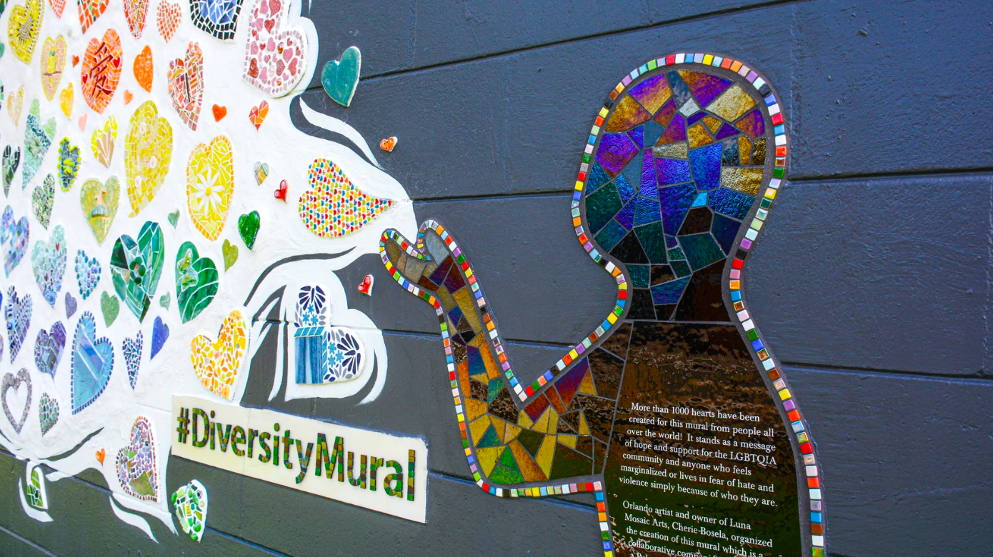 A mosaic of an irridescent figure blowing hearts with the words diversity mural underneath