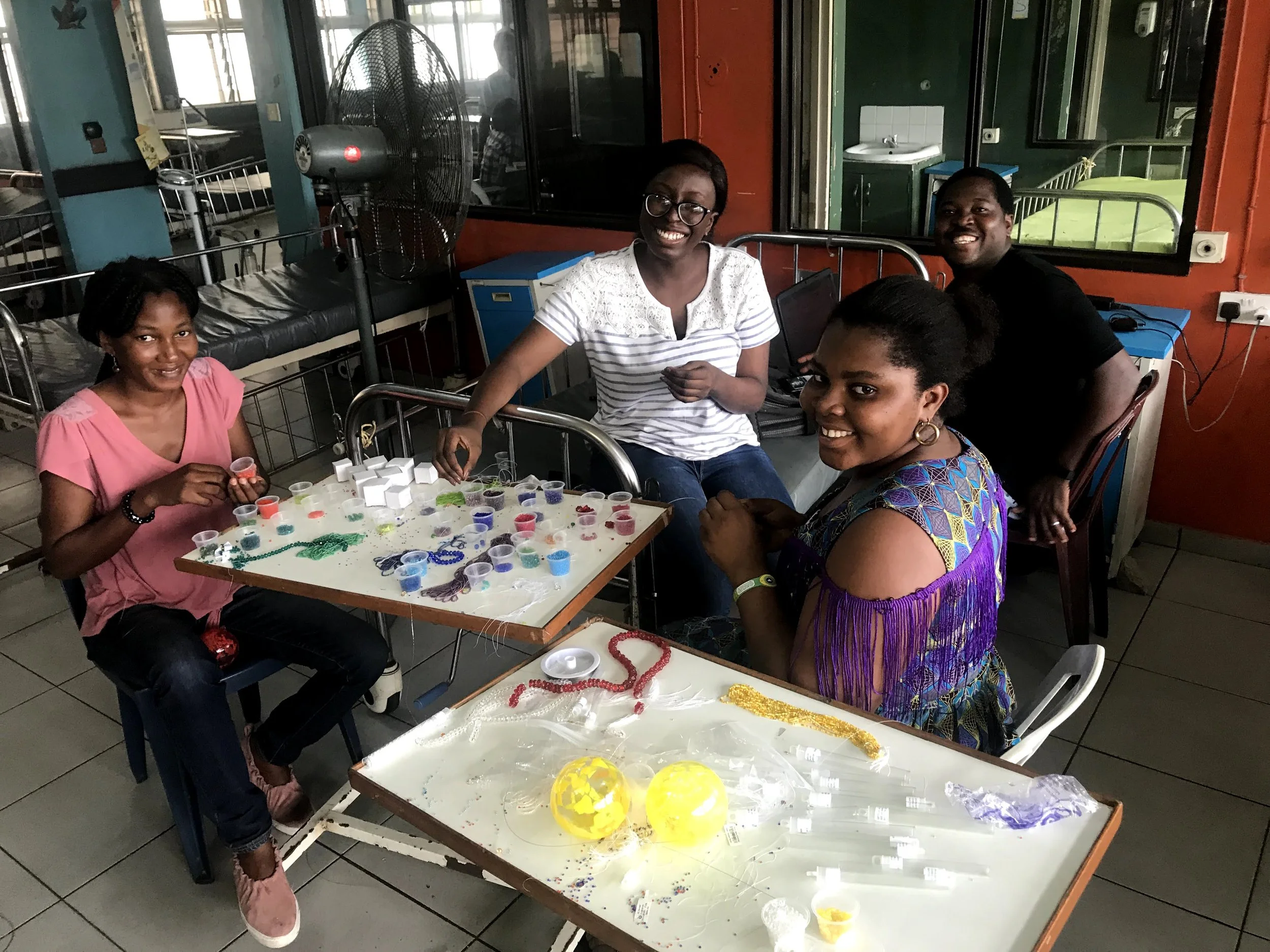 A smiling group of women beading