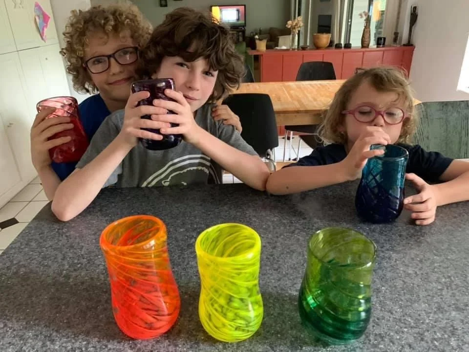 cute kids holding rainbow colored handblown glasses