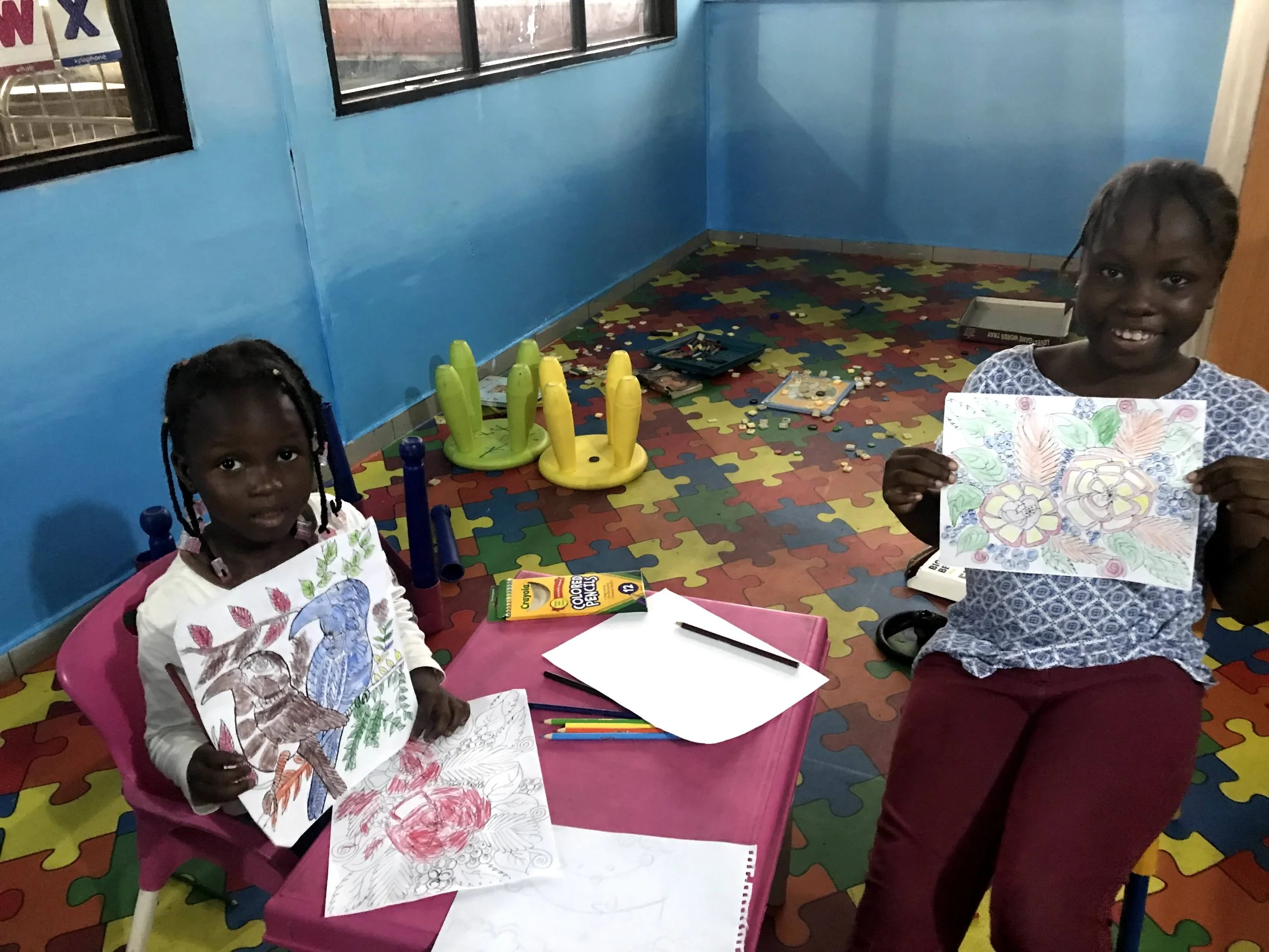 children hold up beautiful coloring pages 