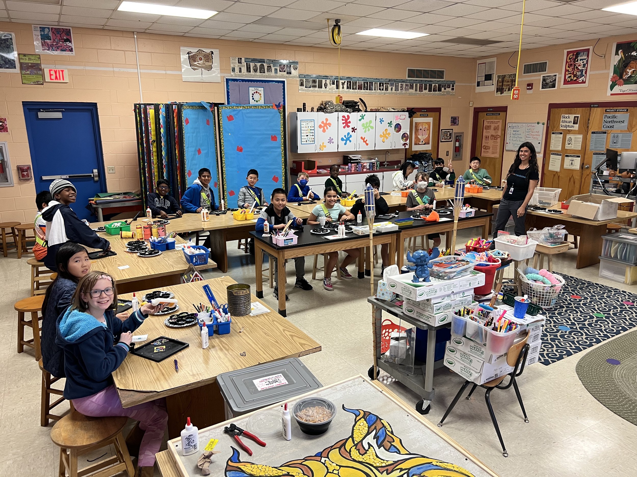 Artist and classroom of students smile 