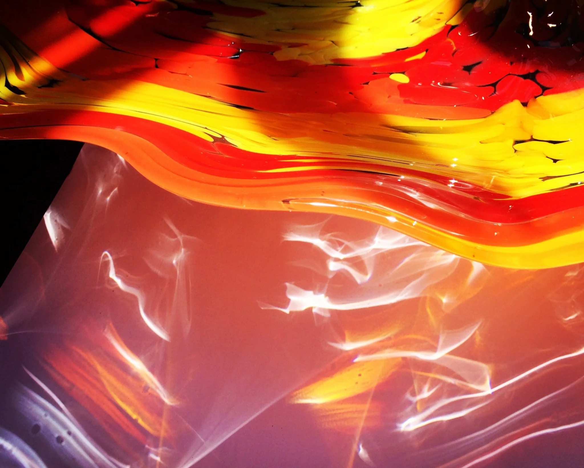A red and yellow glass platter with colored shadows 