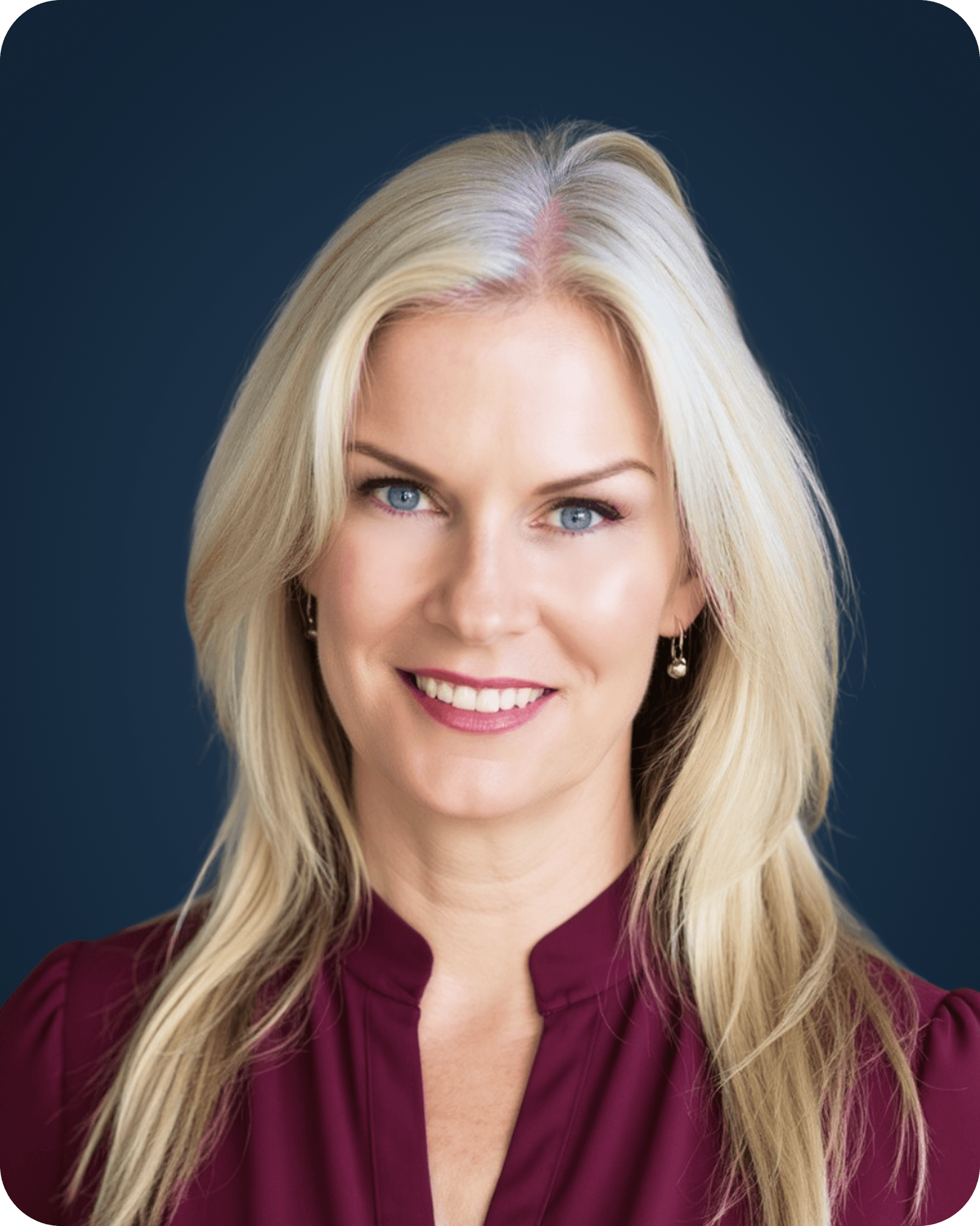 A woman with long blonde hair, blue eyes, and a bright smile, wearing a burgundy top, against a dark background.