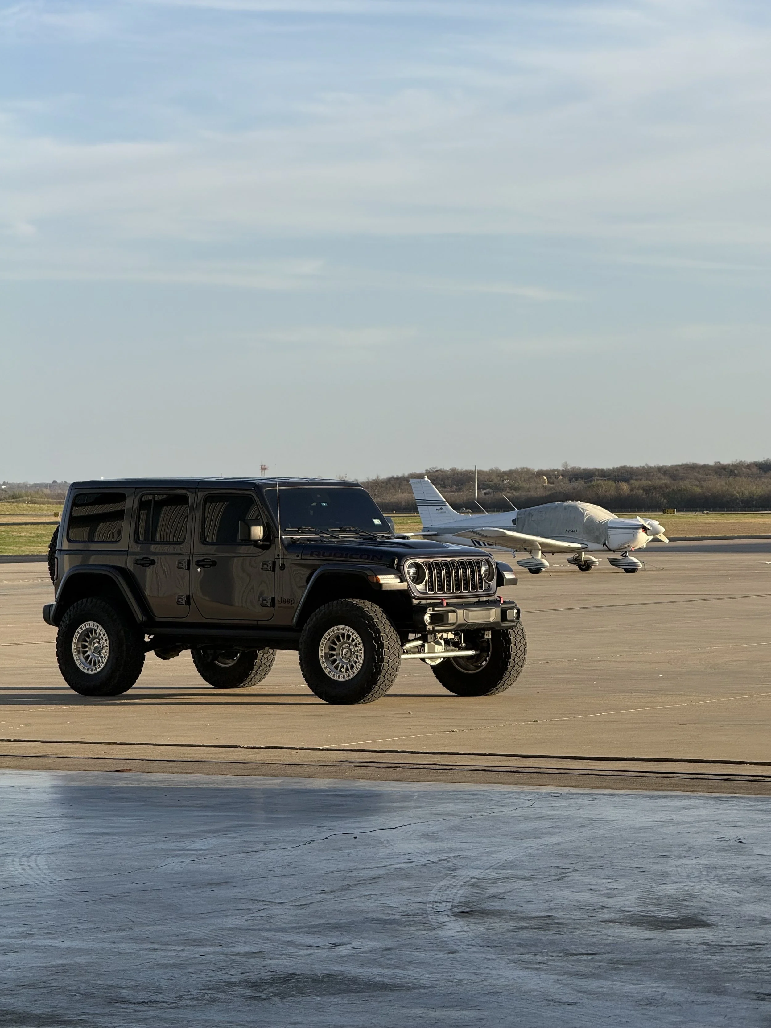 Jeep Laredo and a Cessna plane, both sitting on a runway