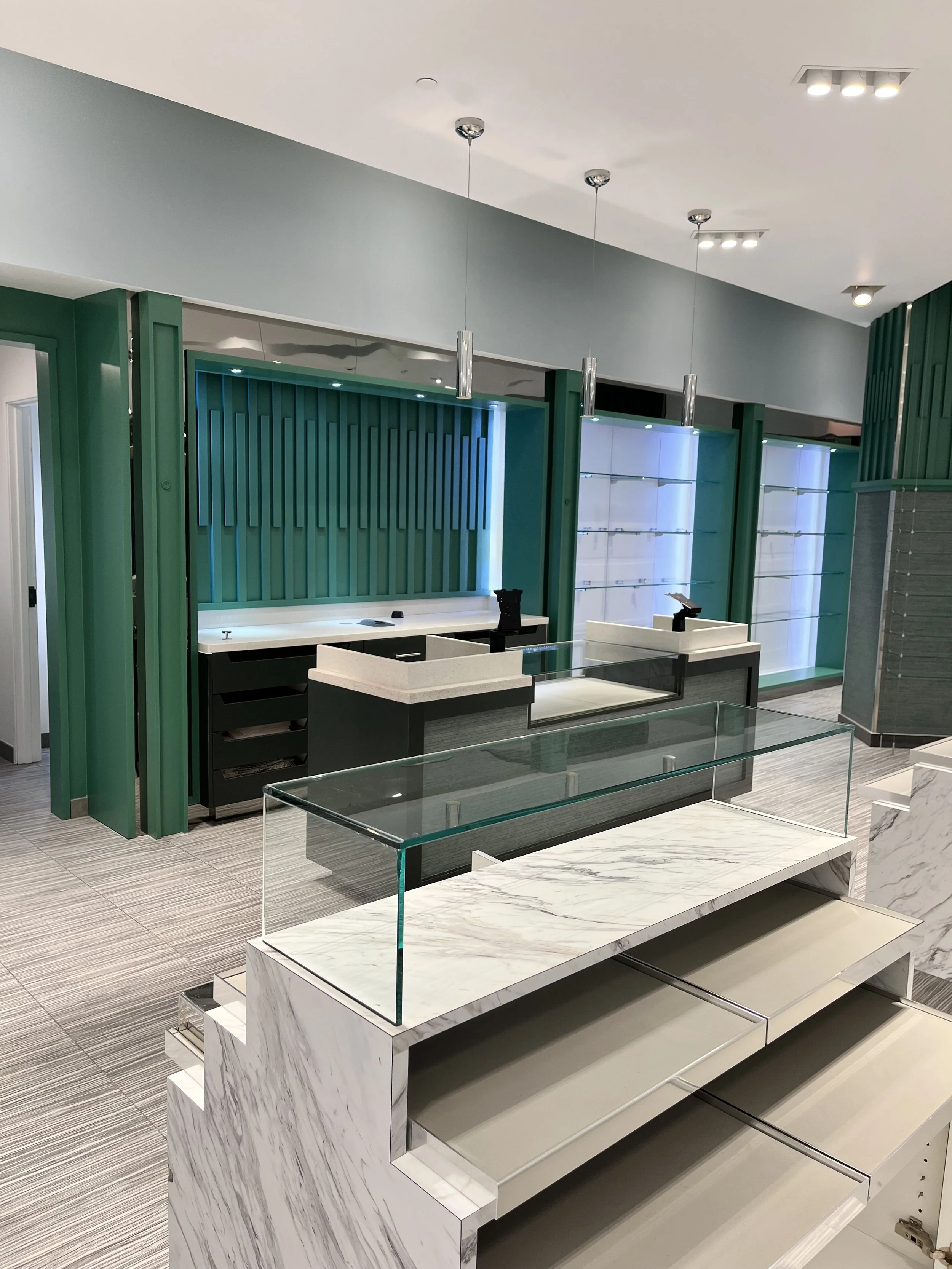Empty retail display and checkout counters in a modern store with teal and gray interior design.