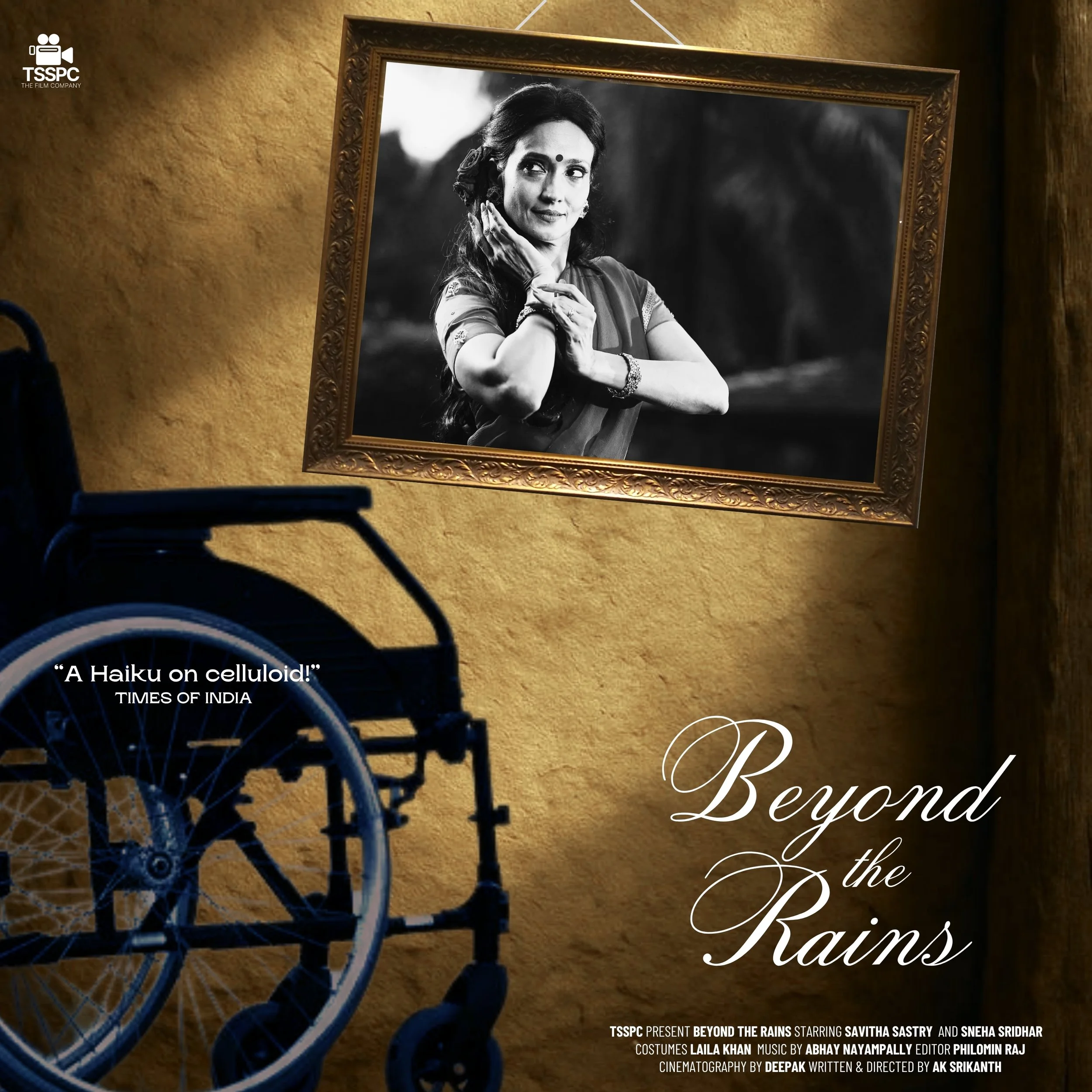 A lit poster shows a black and white portrait photograph of a woman with long hair, dressed in traditional clothing, with her hands positioned near her face. A wheelchair is positioned in the foreground, partly visible. The poster features the title "Beyond the Rains" in elegant script and a quote, "A Haiku on celluloid!" from Times of India, with additional text about the production.