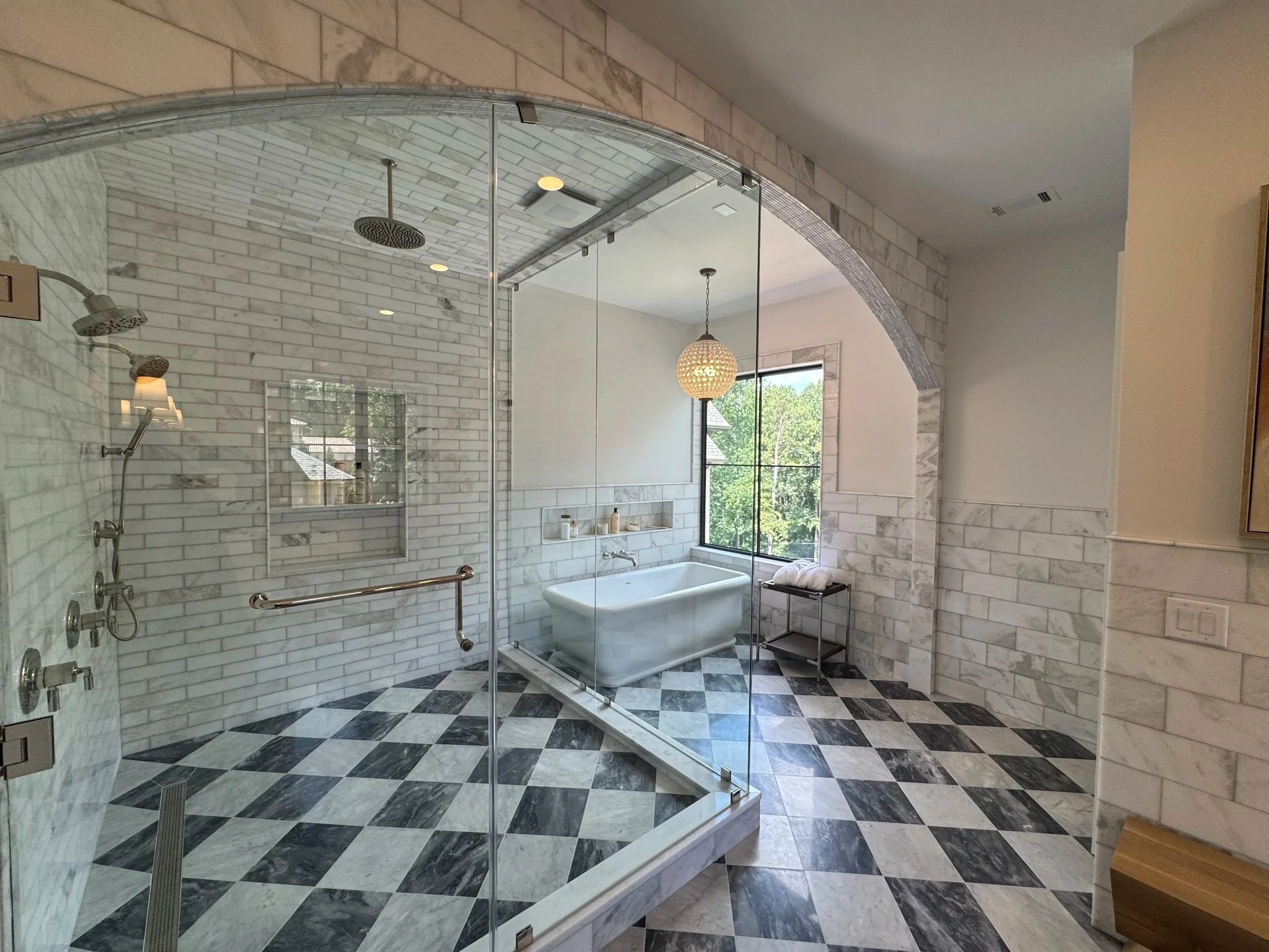 Custom  sunlit bathroom with large walk-in shower, soaking tub and intricate marble tiles