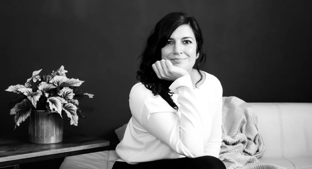 Amelia sitting on a sofa looking at the camera with a confident calm expression