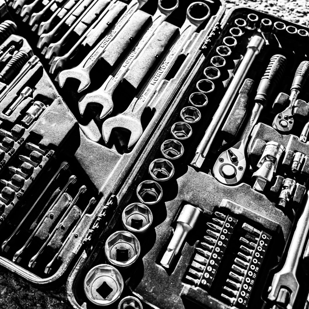 A set of tools arranged in a toolbox, representing the practical tools and frameworks used in leadership coaching.