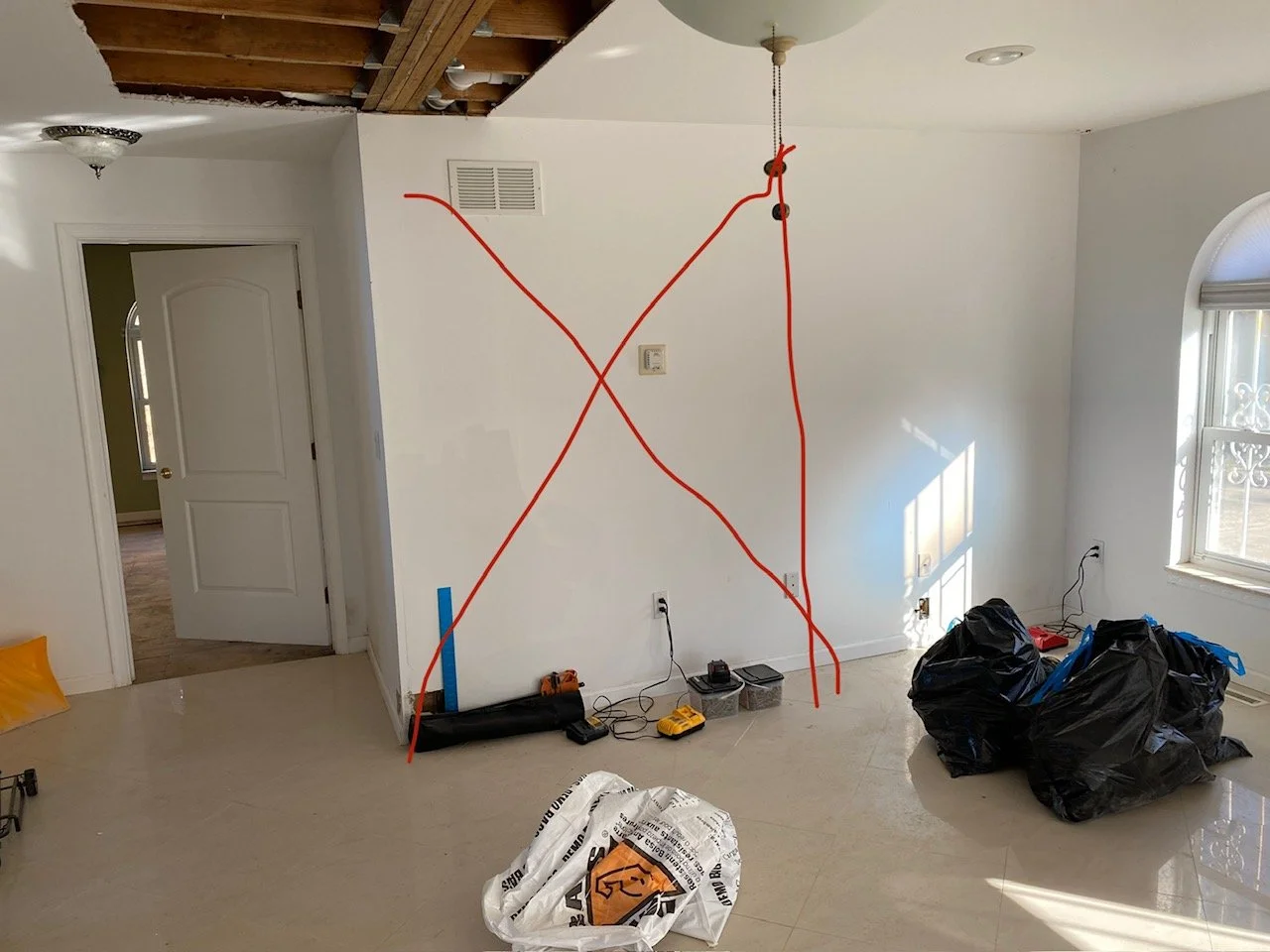 Second wall marked with red X, ceiling partially opened revealing framing above