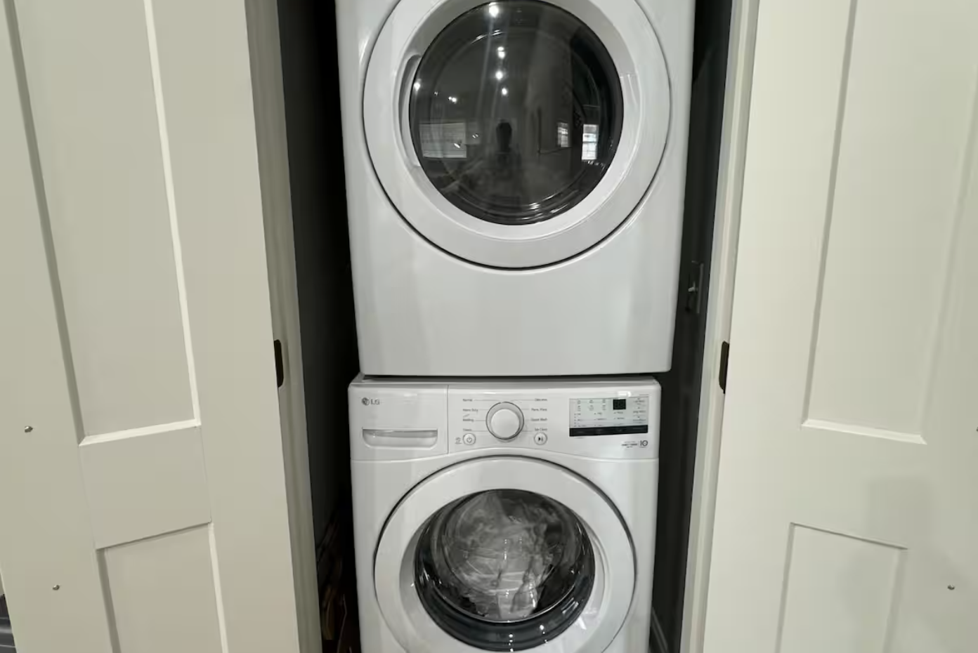Stacked front-loading washing machine and dryer in a small closet.