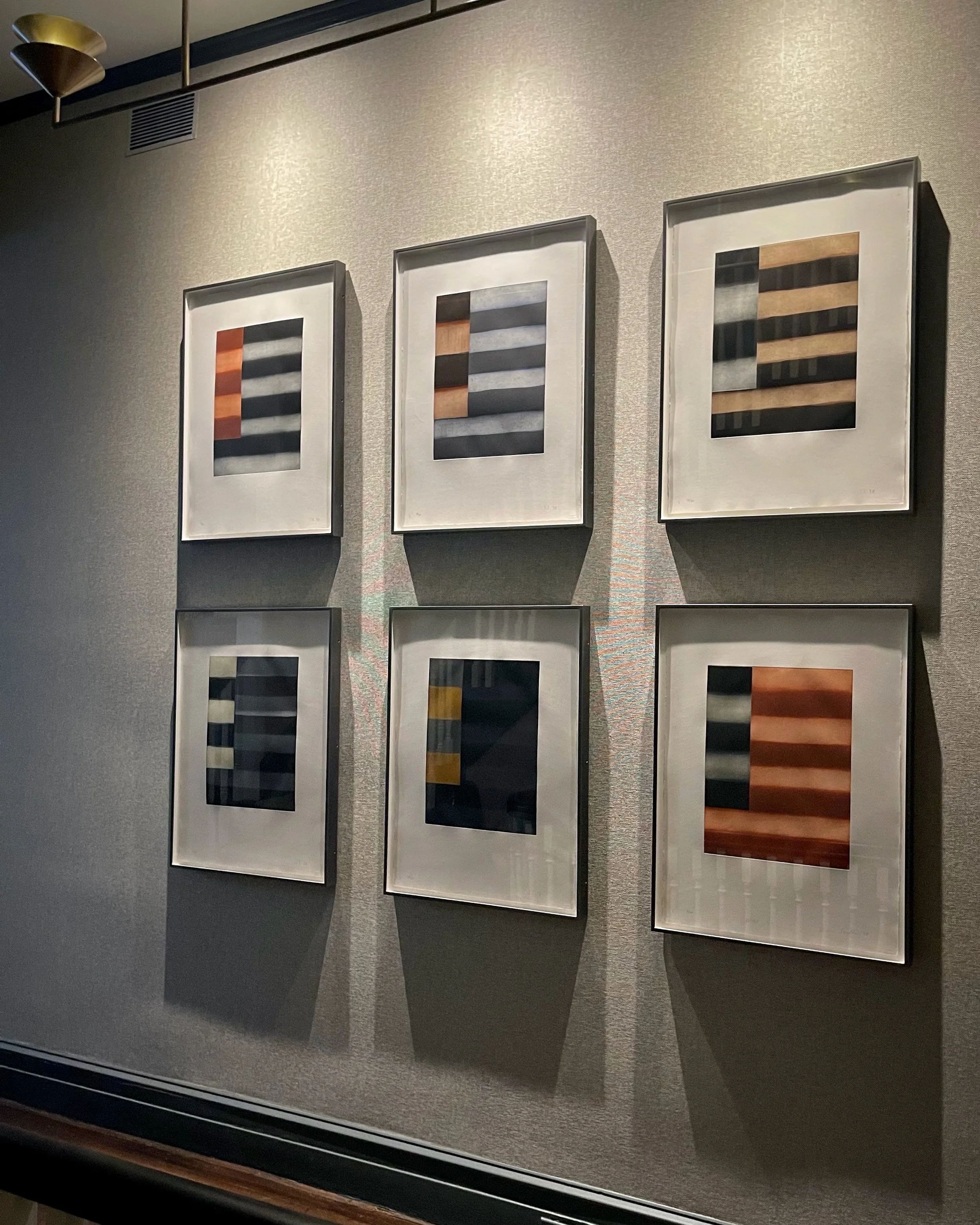 Grid installation of framed abstract works by Sean Scully with gallery-style lighting on textured wall, residential interior styling by Alexander Mann
