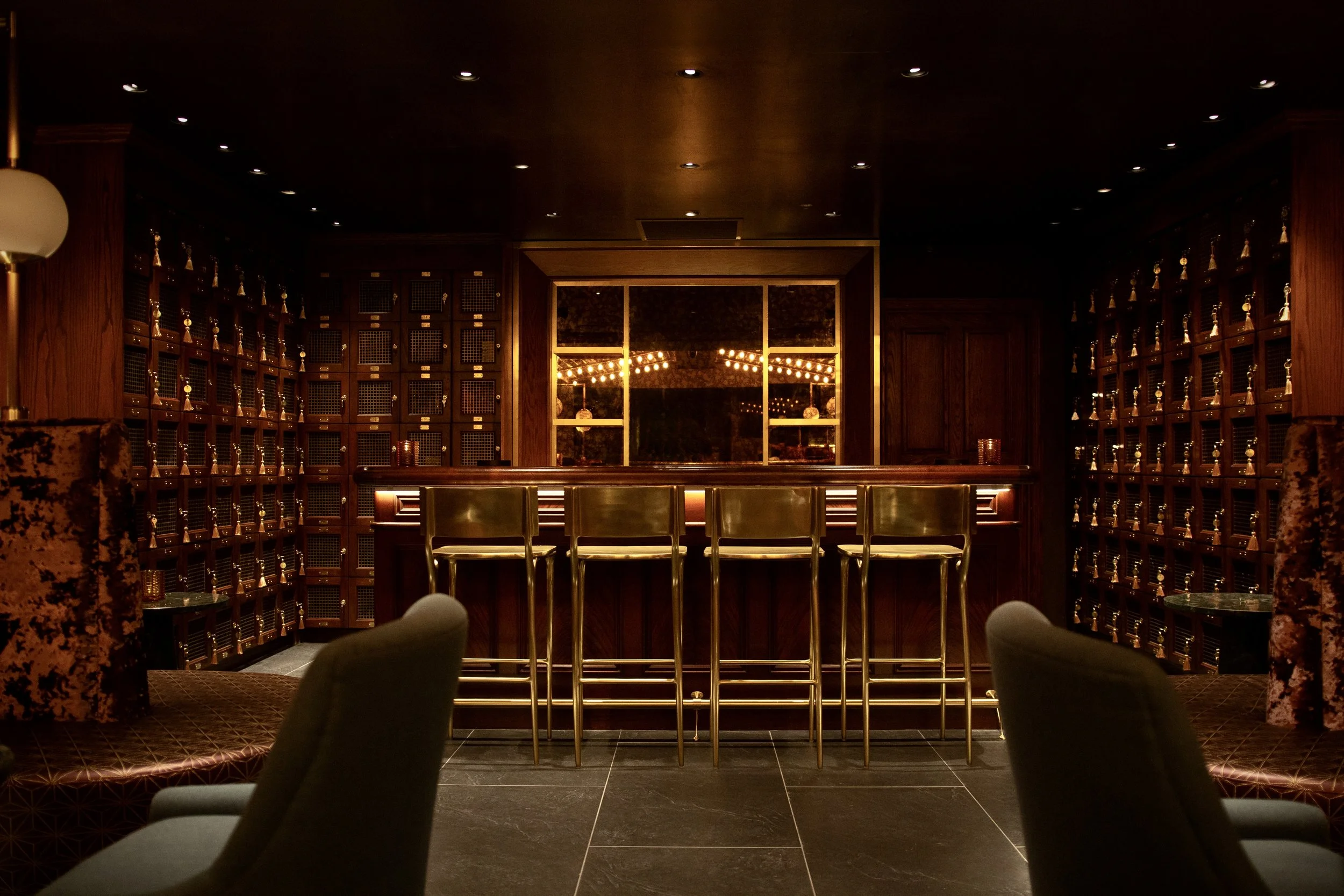 Alexander Mann hospitality interior design, Torches lounge New York, dark walnut bar millwork, brass barstools, Nat Sherman townhouse