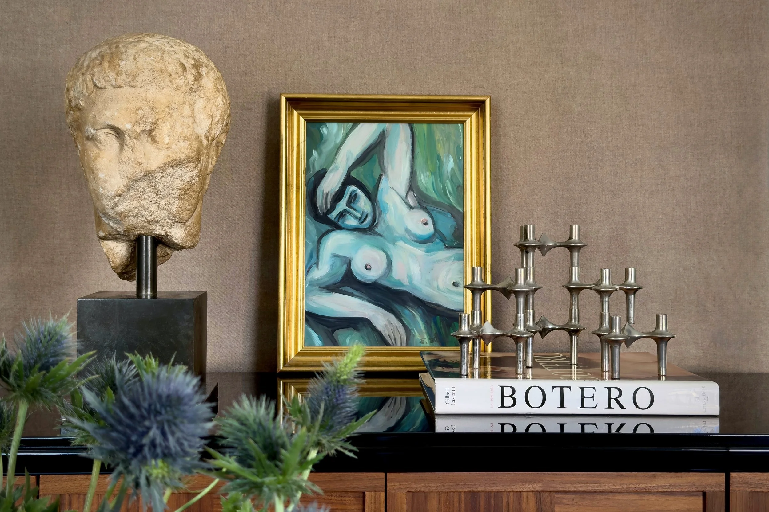 Roman marble head, Botero book, and framed artwork styled on console with Stoff Nagel candle holder, residential interior by Alexander Mann