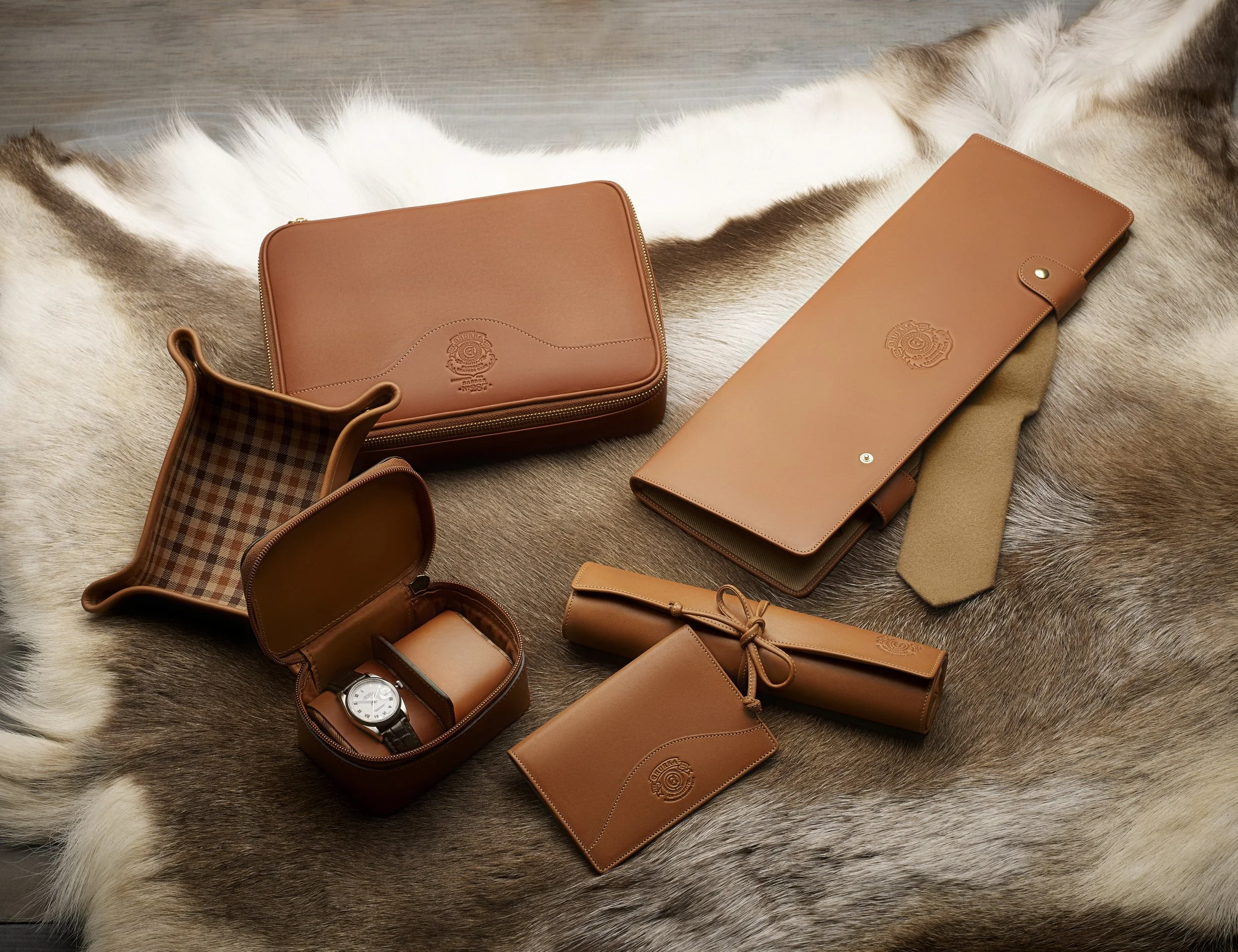 Ghurka leather accessories arranged on hide surface, luxury product styling and art direction by Alexander Mann
