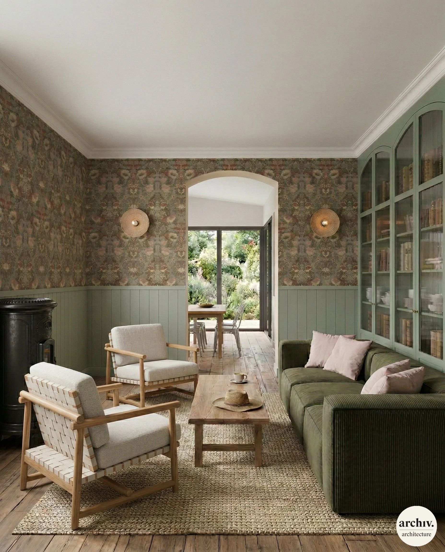 Living room with green sofa, two modern armchairs, wooden coffee table, and a built-in green bookcase. The room opens to a garden area with outdoor dining table visible through an arched doorway and glass sliding door. Reims.