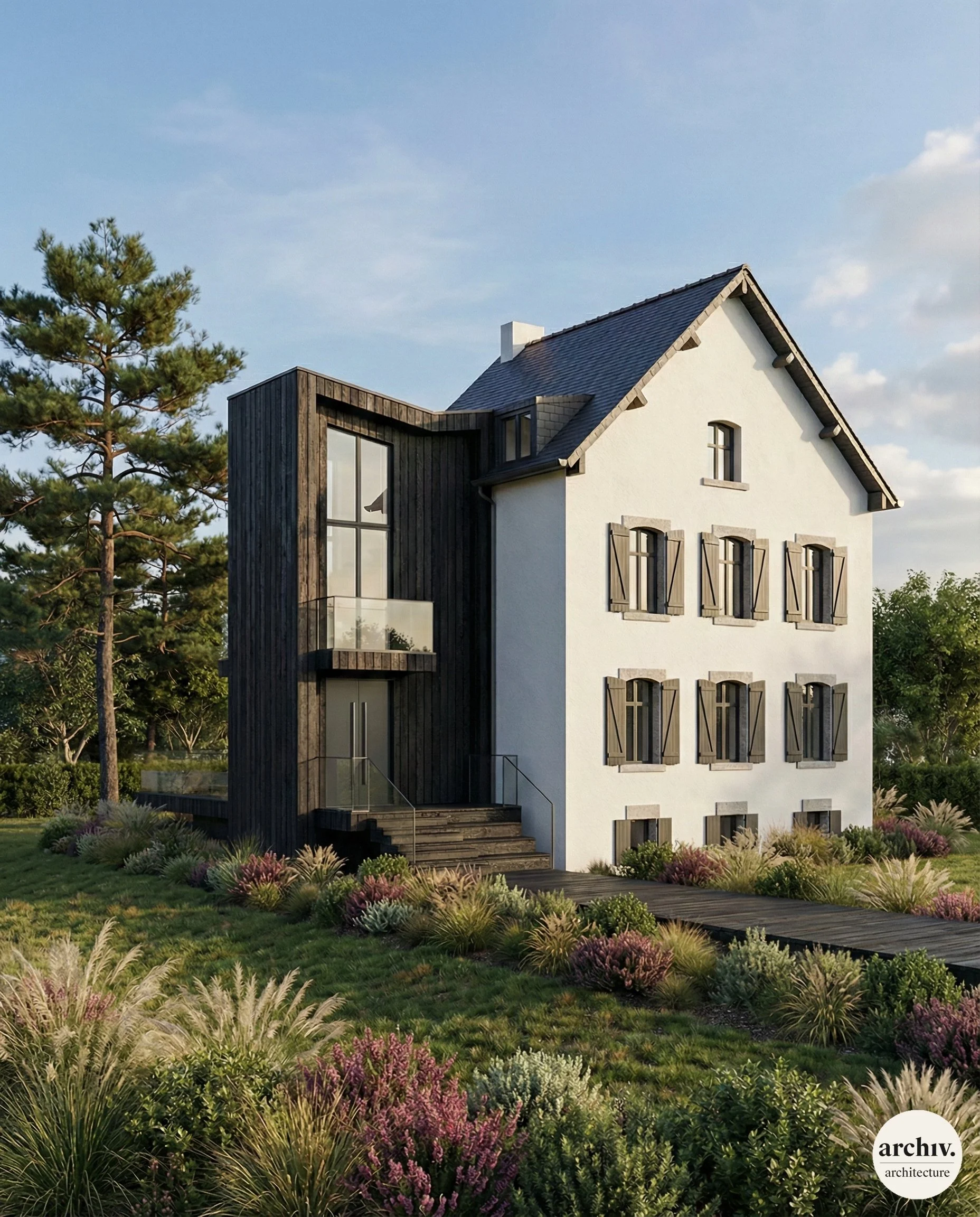 Renovated house with white facade, black shutters, and a contemprorary black wooden extension, surrounded by landscaped garden with grass, bushes, and trees under a blue sky. Bretagne.