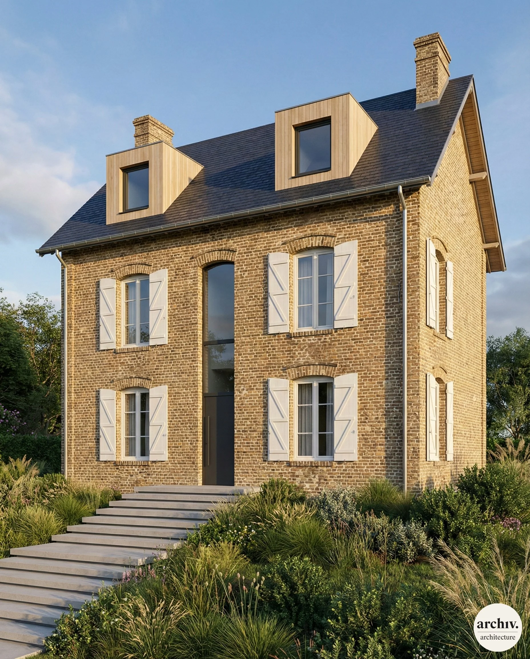 A three-story brick house with white shutters on the windows and a modern wooden dormer on the roof. There are stairs leading up to the front door, surrounded by green shrubs and plants.  Reims.