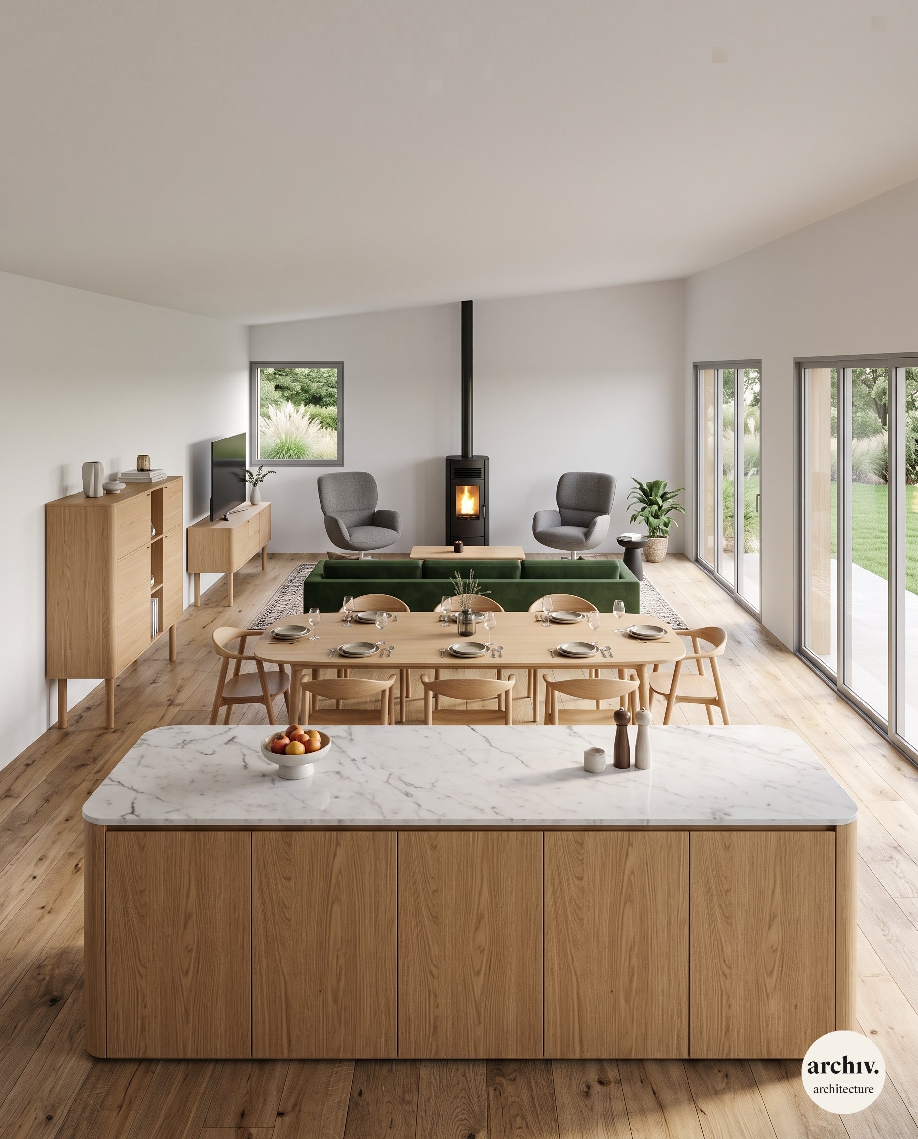 Une cuisine moderne avec un îlot en bois et un plan de travail en marbre, une table à manger en bois. Le fond montre un salon avec un canapé vert et des fauteuils gris, ainsi qu'un poêle à bois .