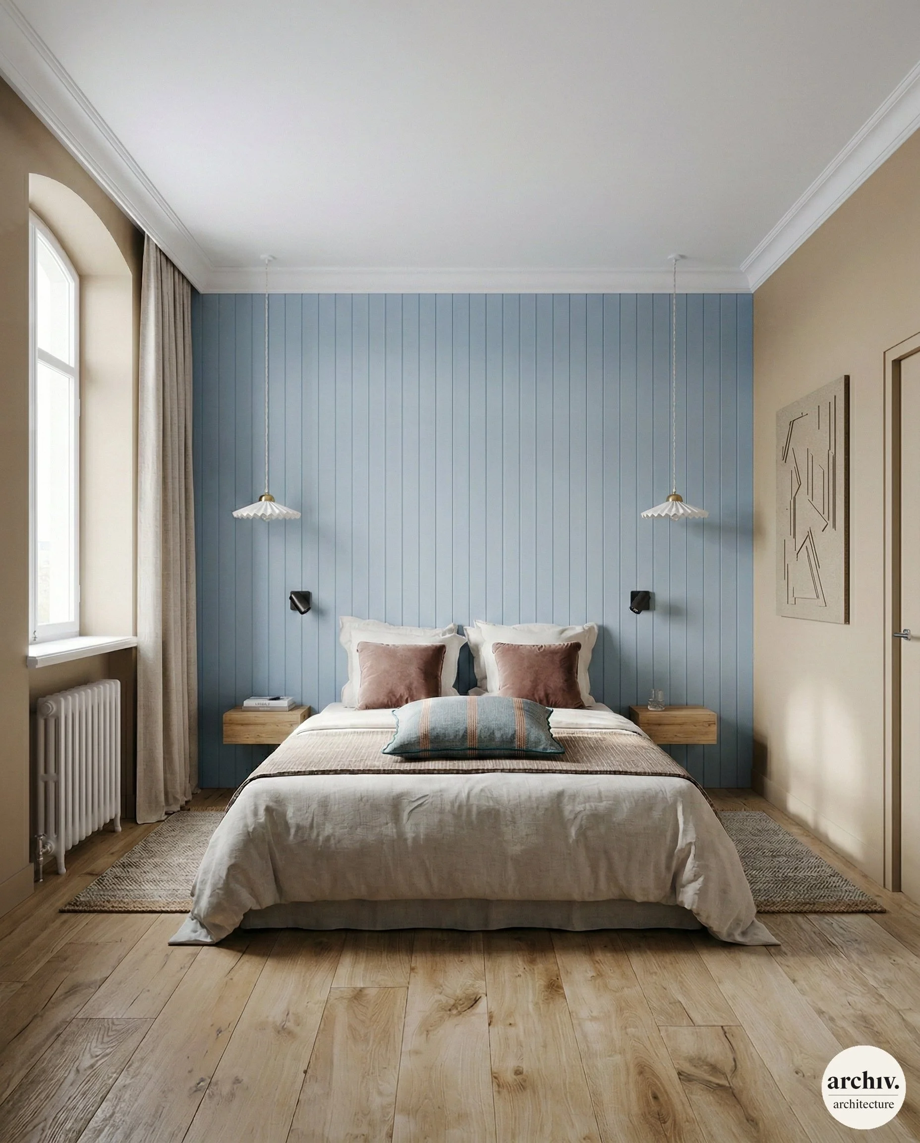 A bedroom with a blue paneled accent wall behind a bed with white and pink pillows. Two pendant lights hang from the ceiling, and there are small floating nightstands on each side of the bed. A window with beige curtains.  Bretagne.