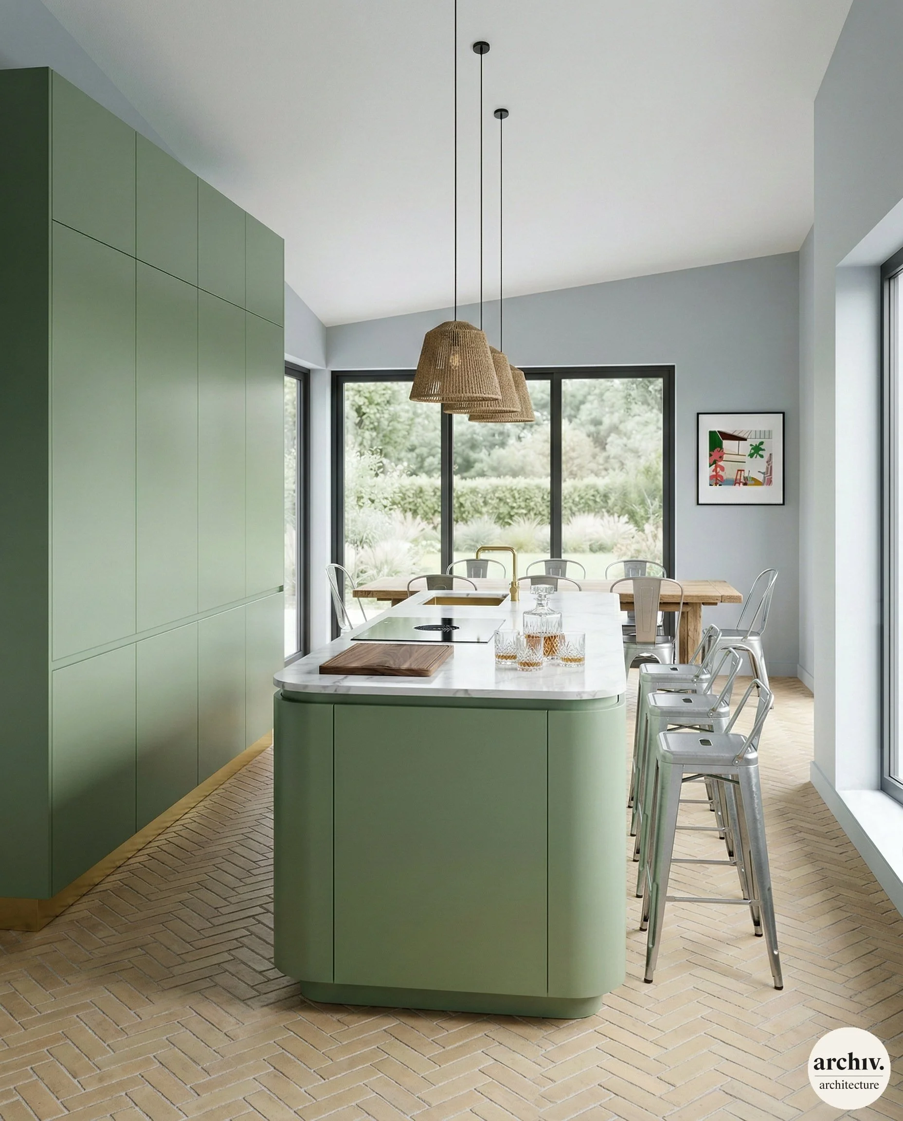 Modern kitchen with green cabinets and island, white marble countertop, hanging rattan pendant lights, metal bar stools, windows with garden view, framed artwork on the wall, tiled herringbone wood floor.  Reims.