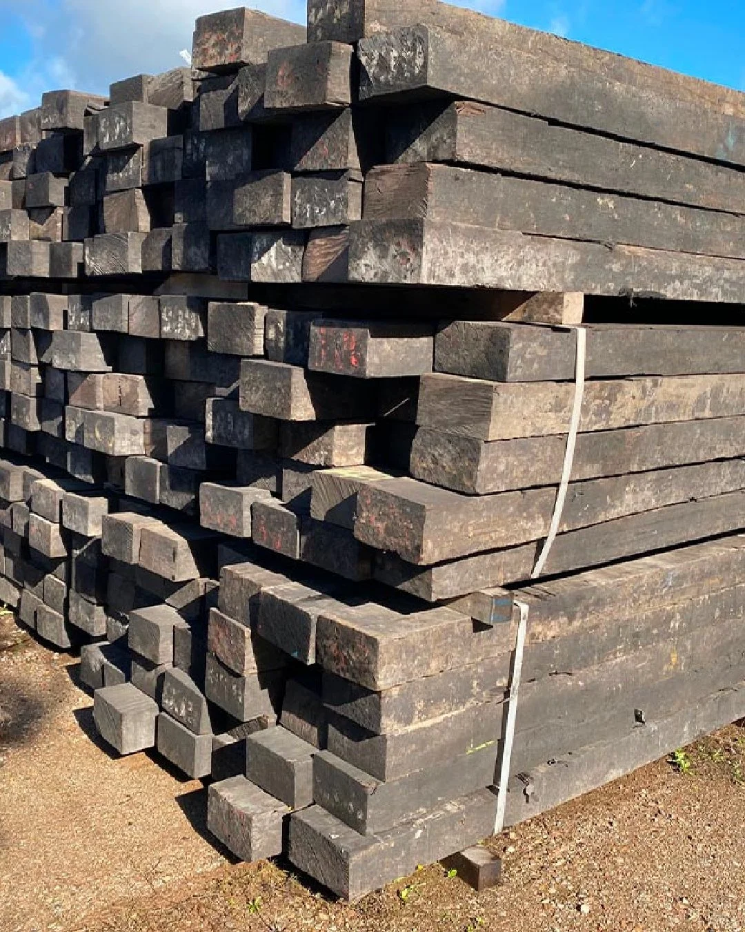 Pile de traverses de bois traitées empilées à l'extérieur pour le réemploi