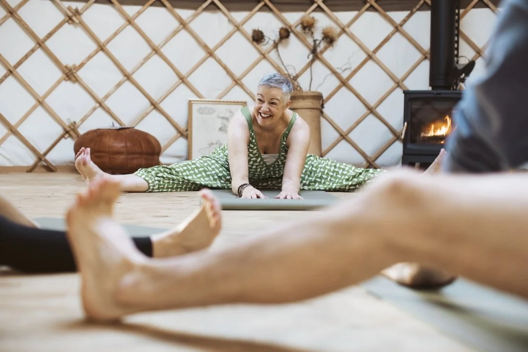 Stephanie teaching yoga in pose in the yurt group class