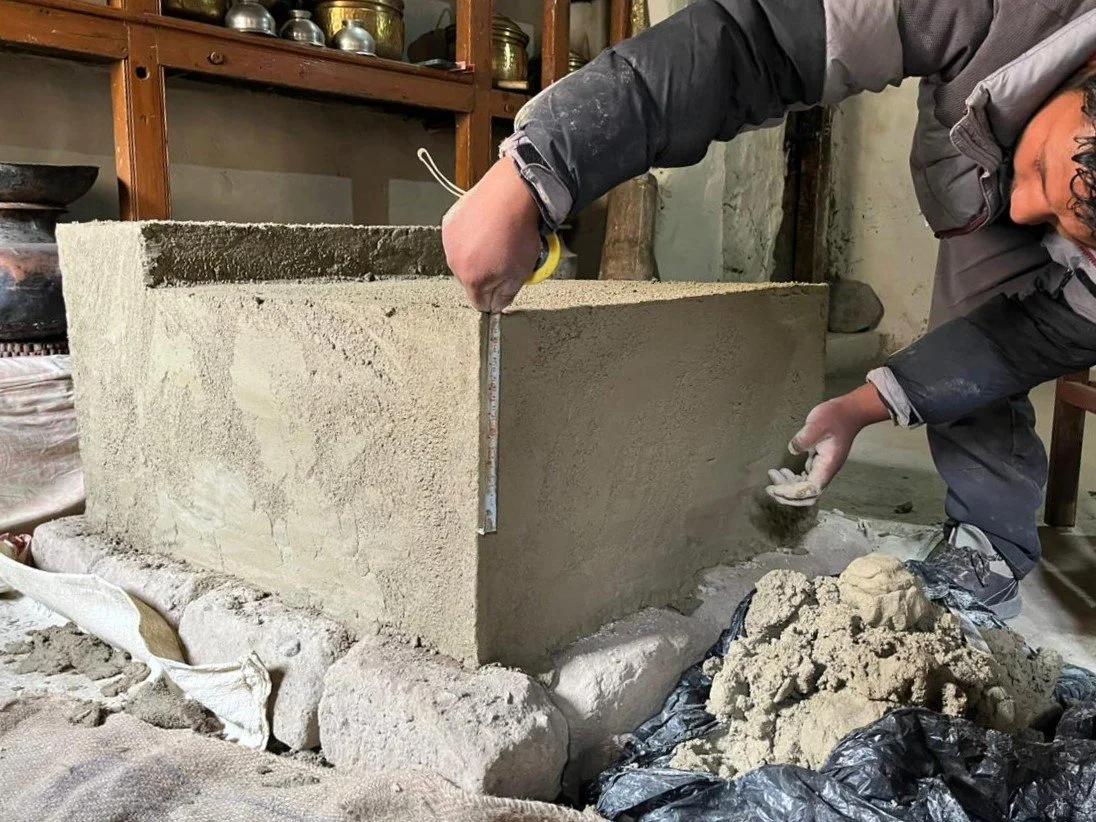 Person smoothing concrete block with trowel in an artisan workshop.