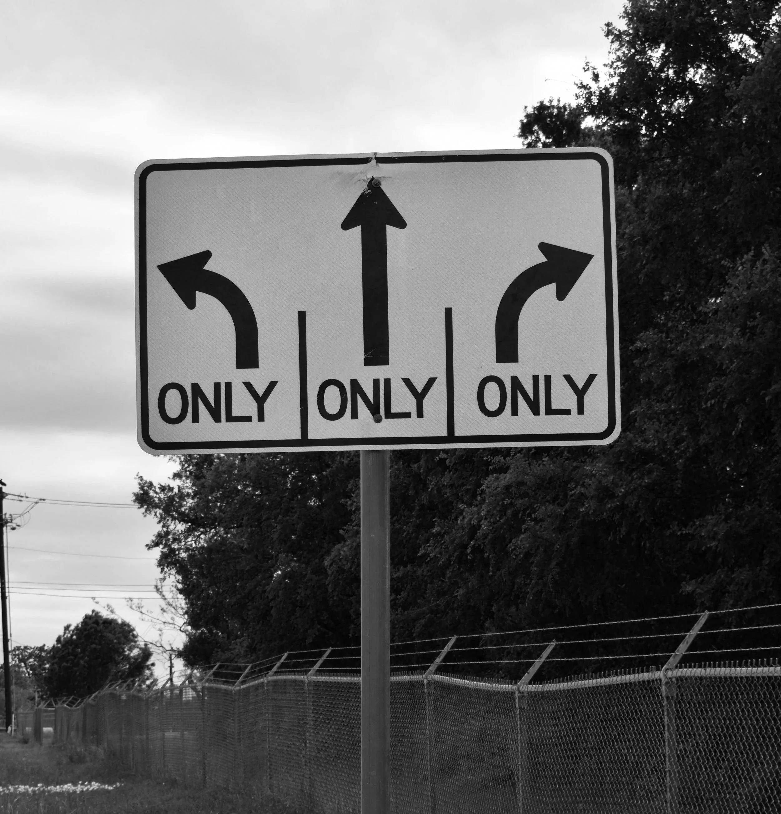 Verkehrsschild mit drei Richtungsangaben: links nur links abbiegen, geradeaus nur geradeaus, rechts nur nach rechts abbiegen.