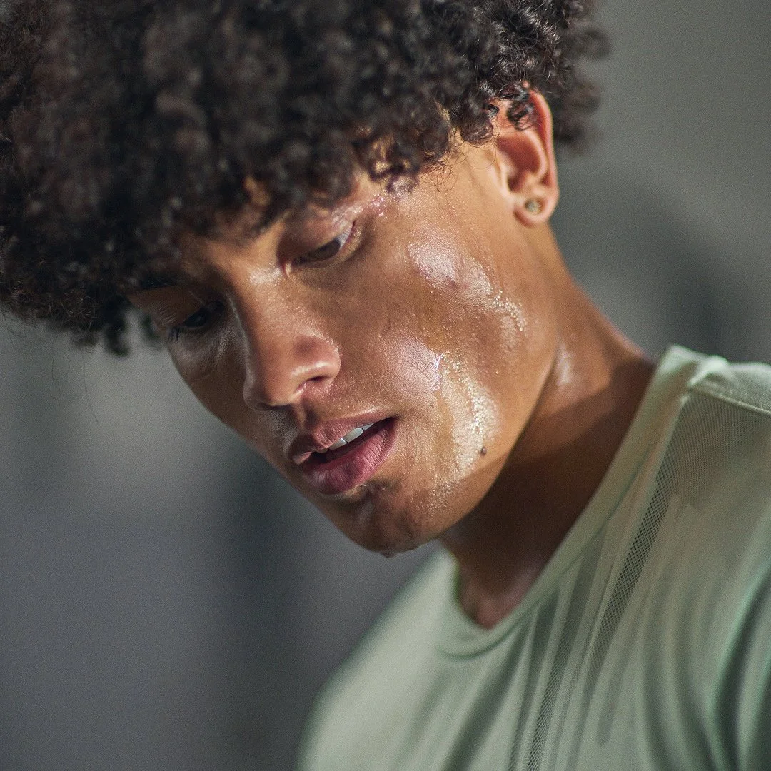 A woman sweating during a workout.