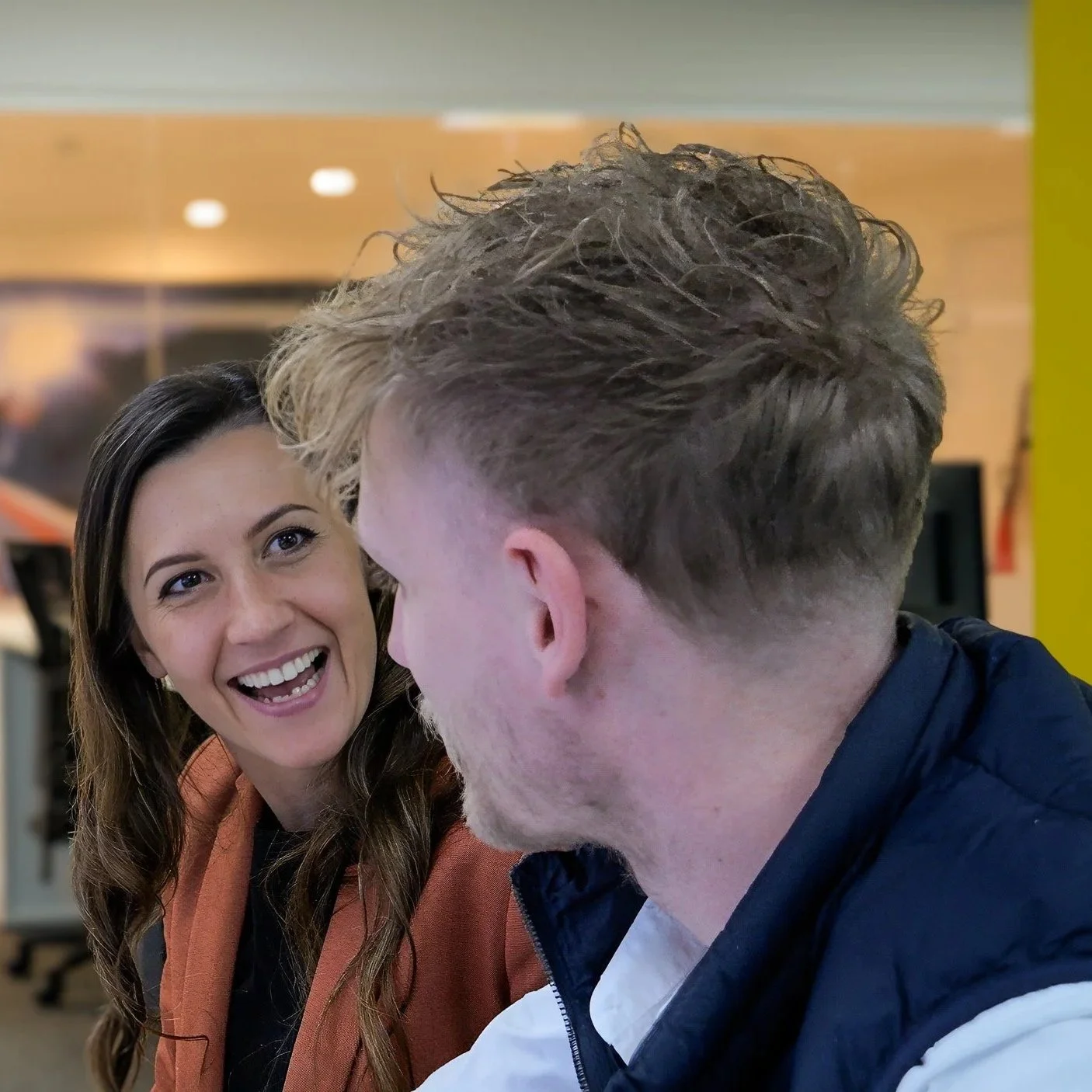 a woman smiling when talking to a man