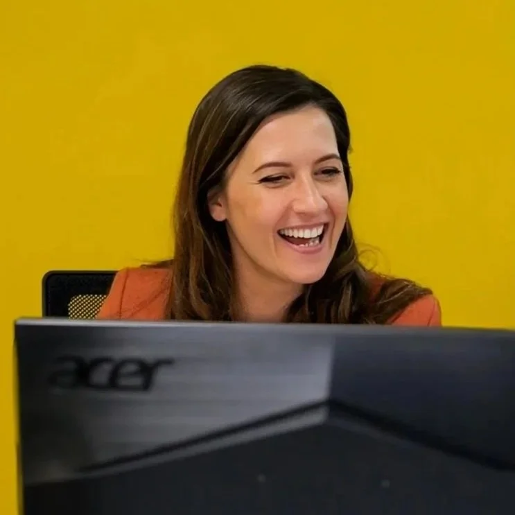Roza Romanowska working at her monitor, smiling. It showcases Roza's enthusiasm and easy-going nature.