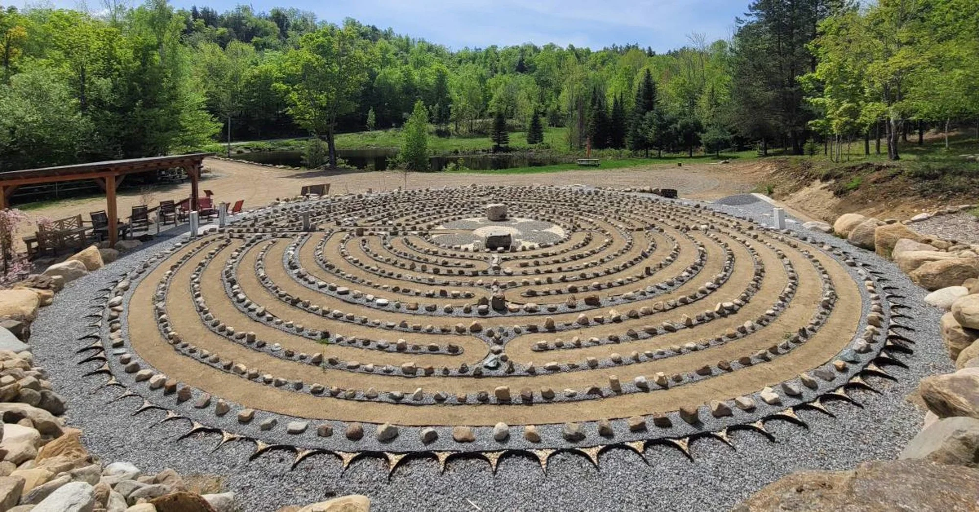 A stone labyrinth against a backdrop of Adirondack forest
