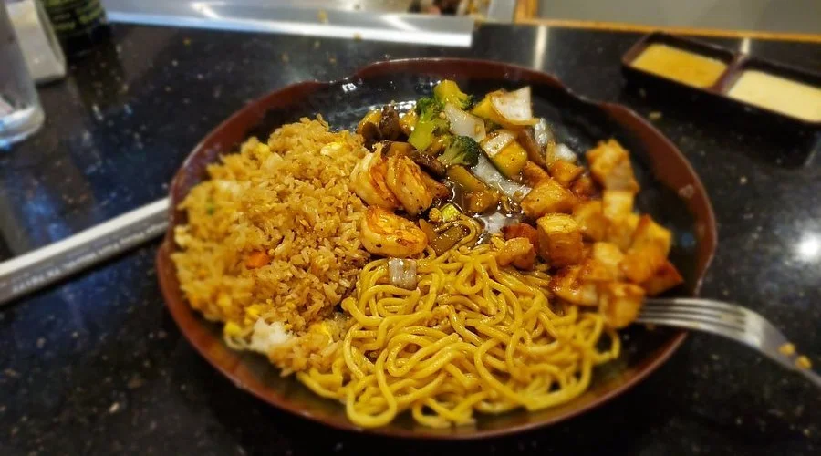 Plate with fried rice, stir-fried noodles, and stir-fried vegetables and chicken.